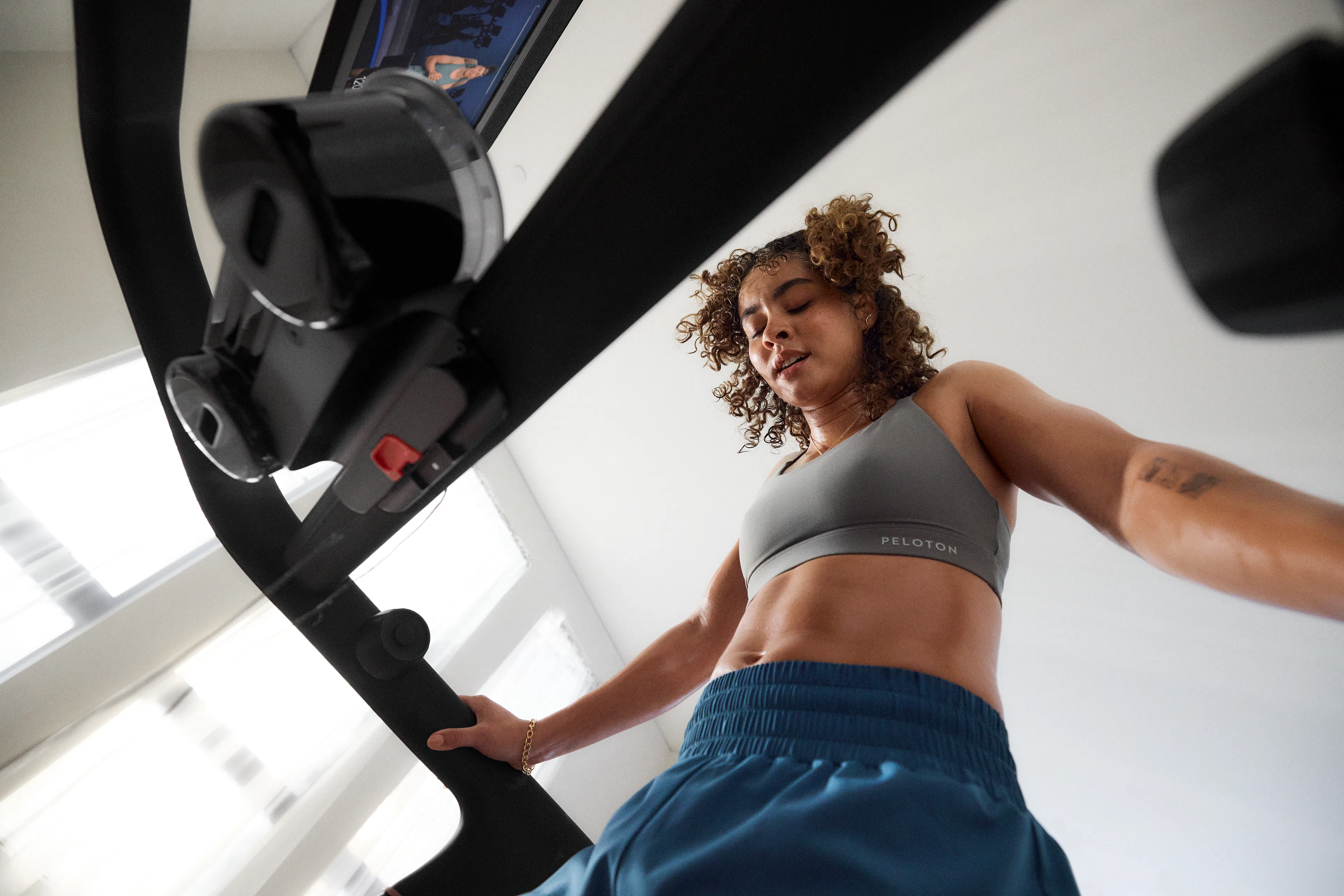 Woman working out on a Peloton Cross Training Tread wondering why running is so hard.