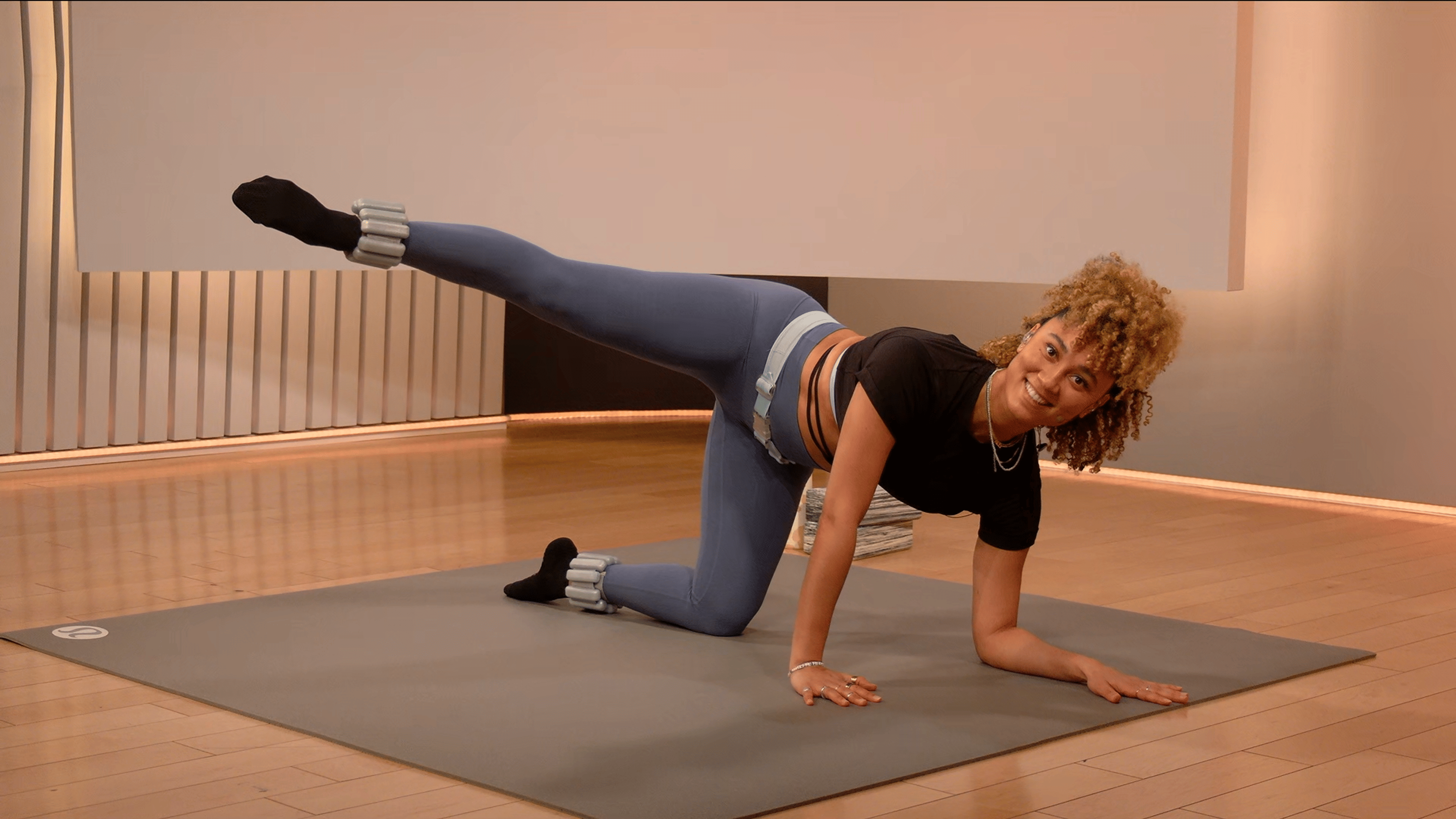 Peloton instructor Ally Love wears ankle weights during a Peloton barre class