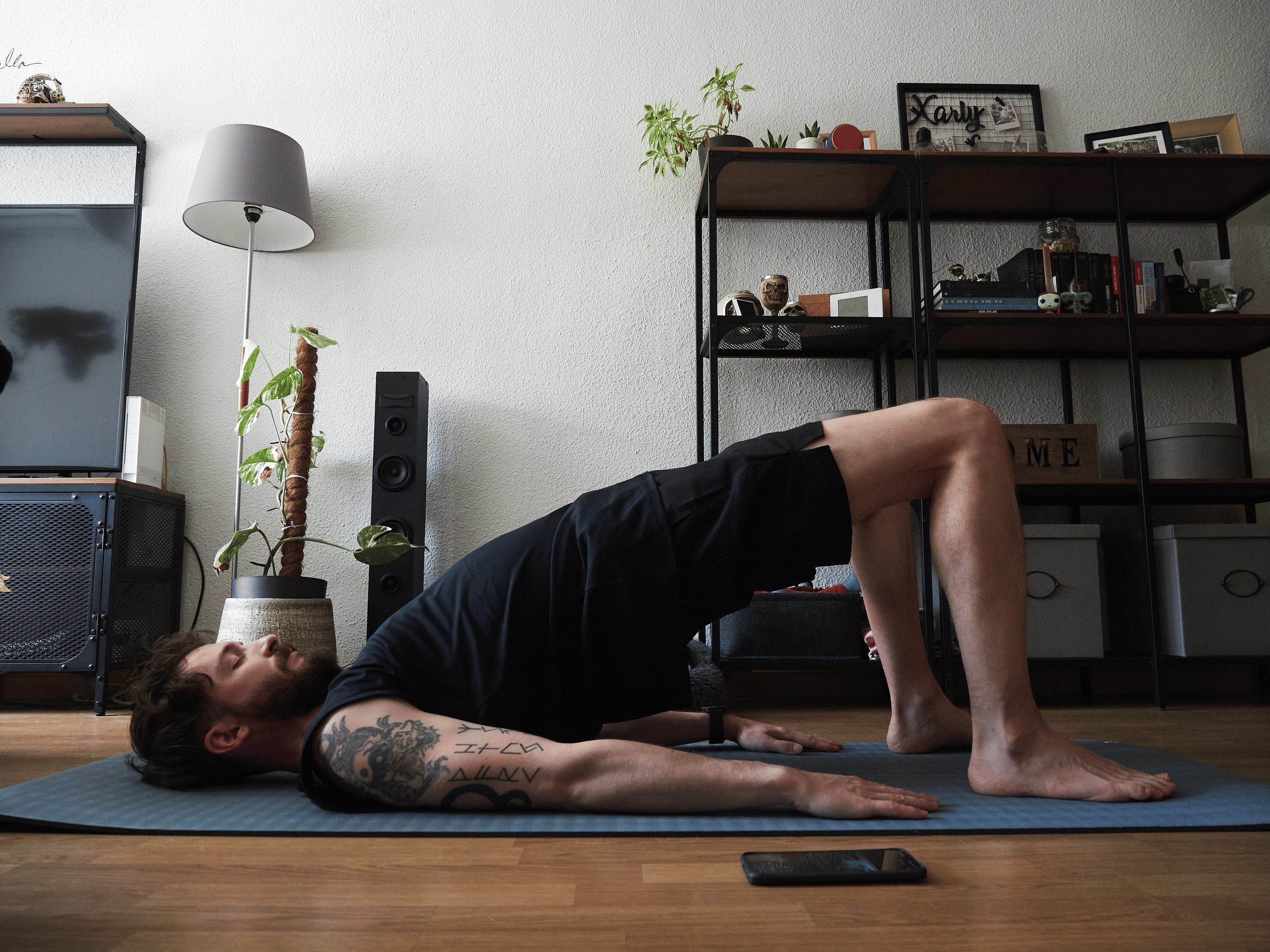 Man doing Bridge Pose in yoga for core strength in his living room 