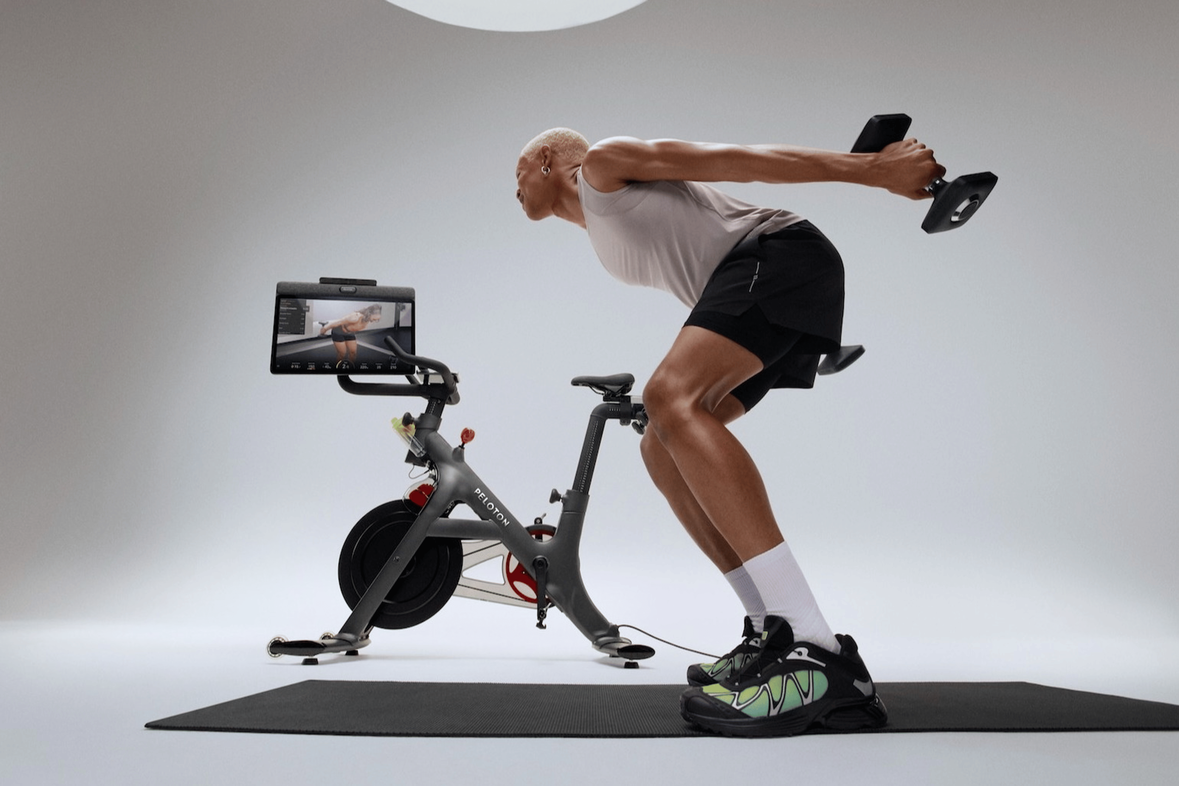 A person doing a Peloton Strength workout using their Peloton Cross Training Bike+.