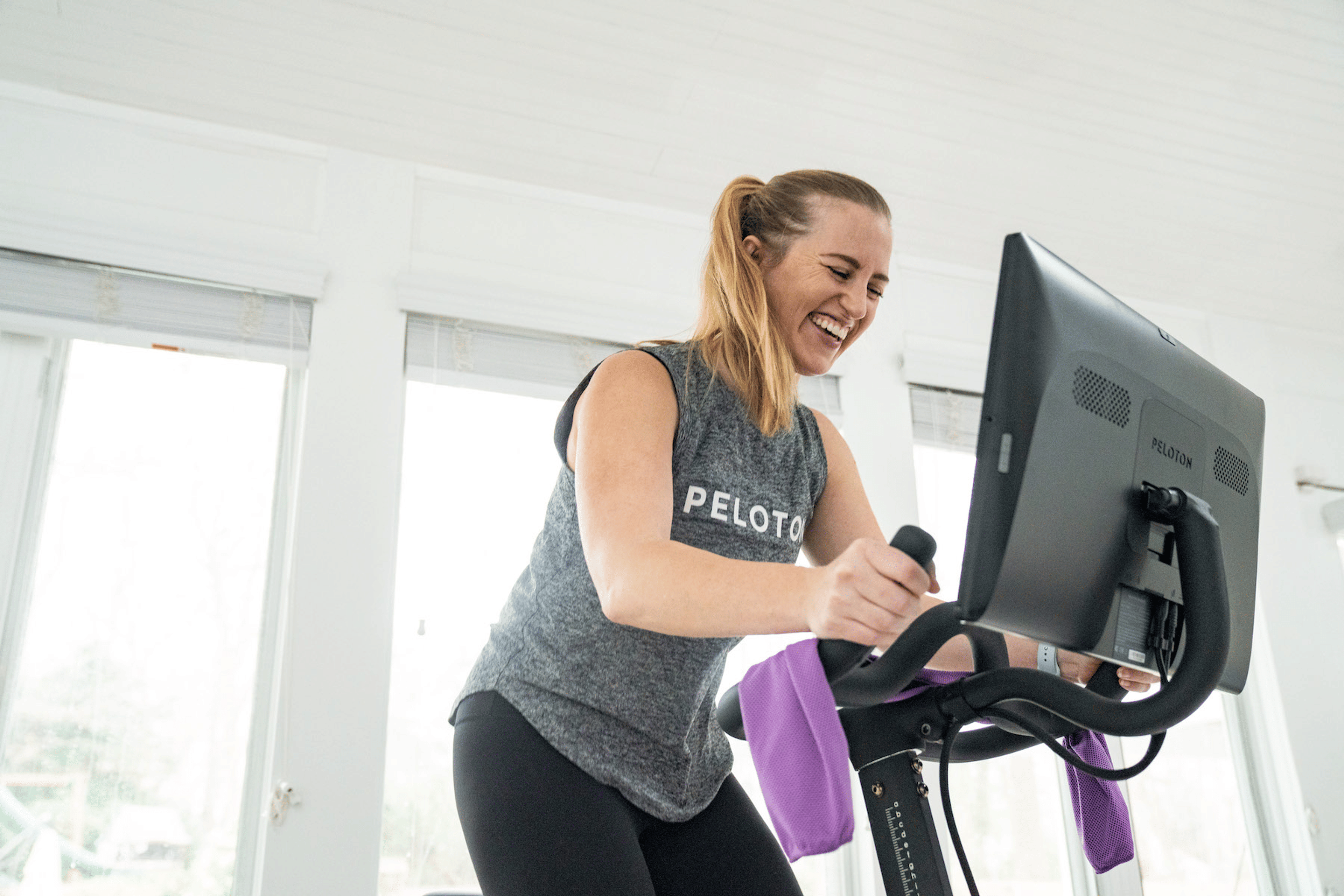 woman riding Peloton bike smiling