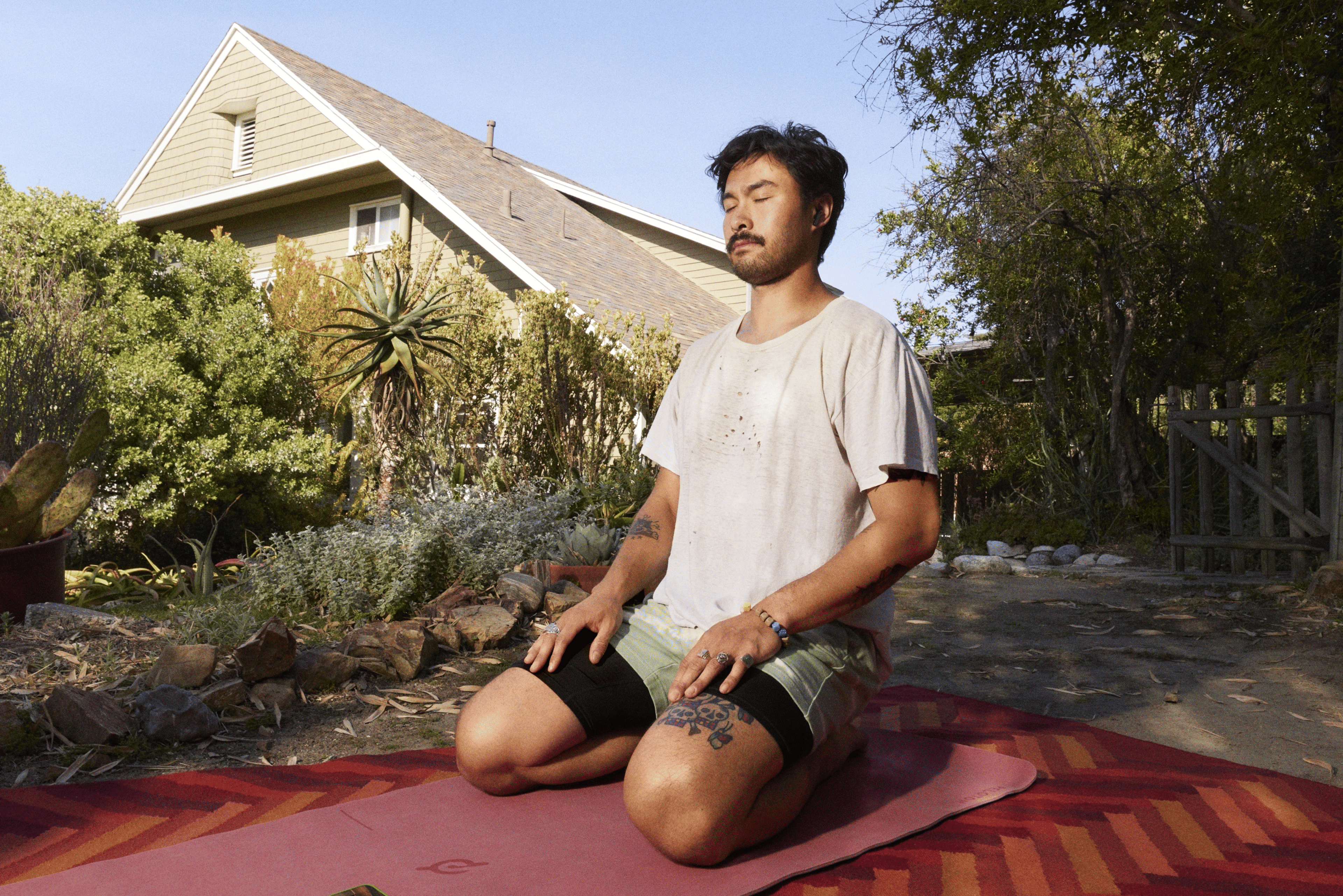 Mann meditiert im Garten