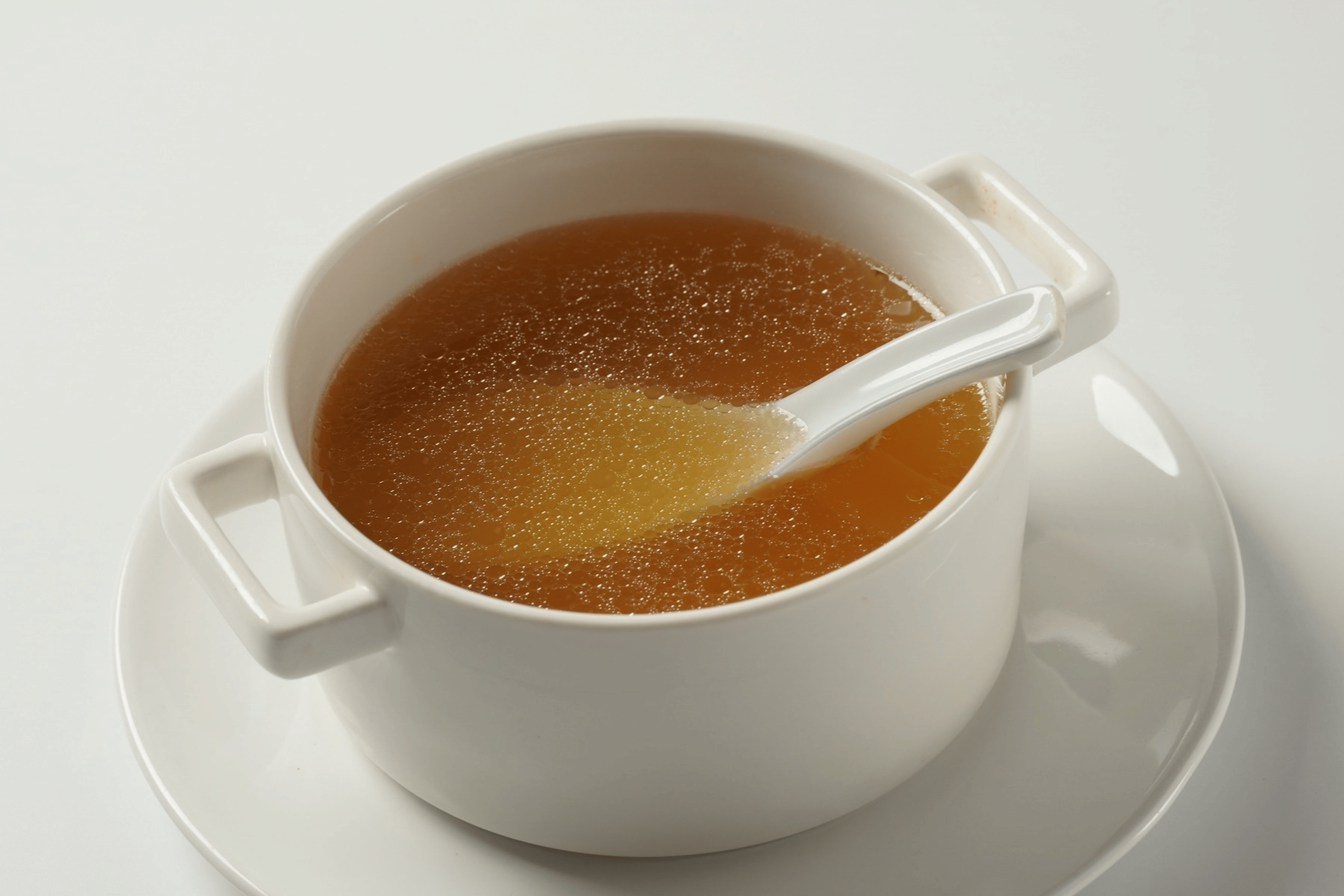 A photo of a cup of bone broth in a white bowl.