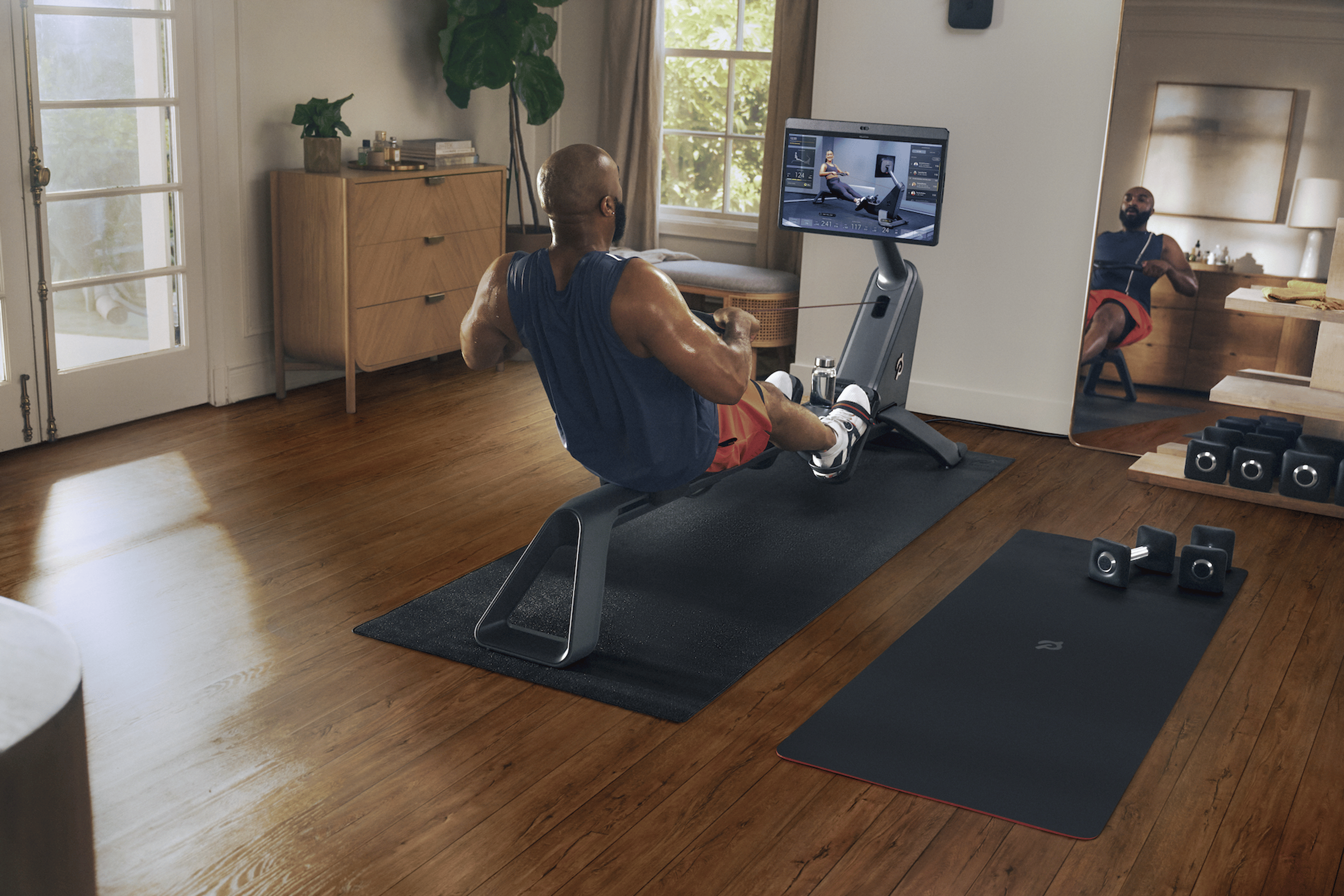 Man does rowing workout at home on Peloton Row