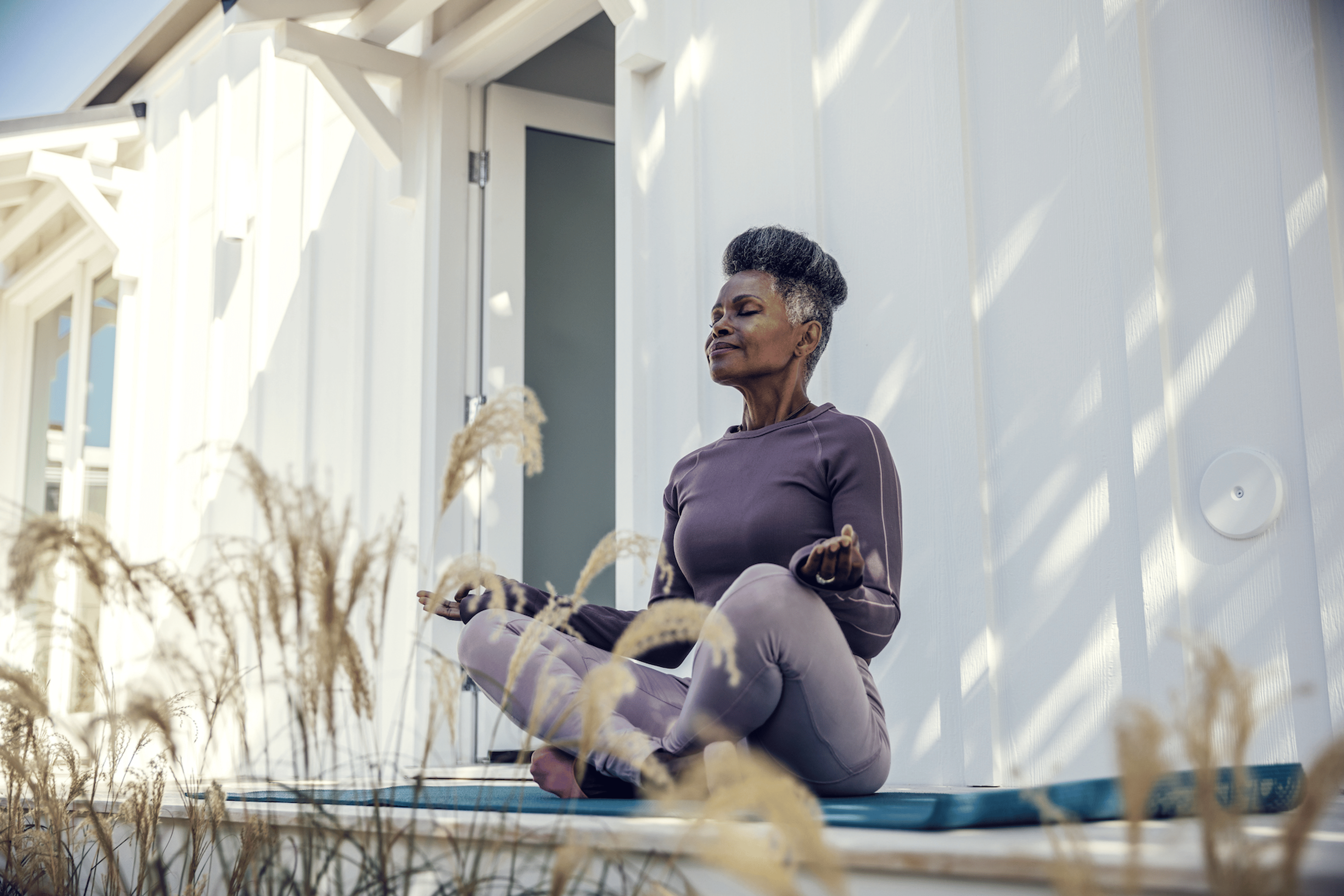 A woman outside practicing meditation before exercise.