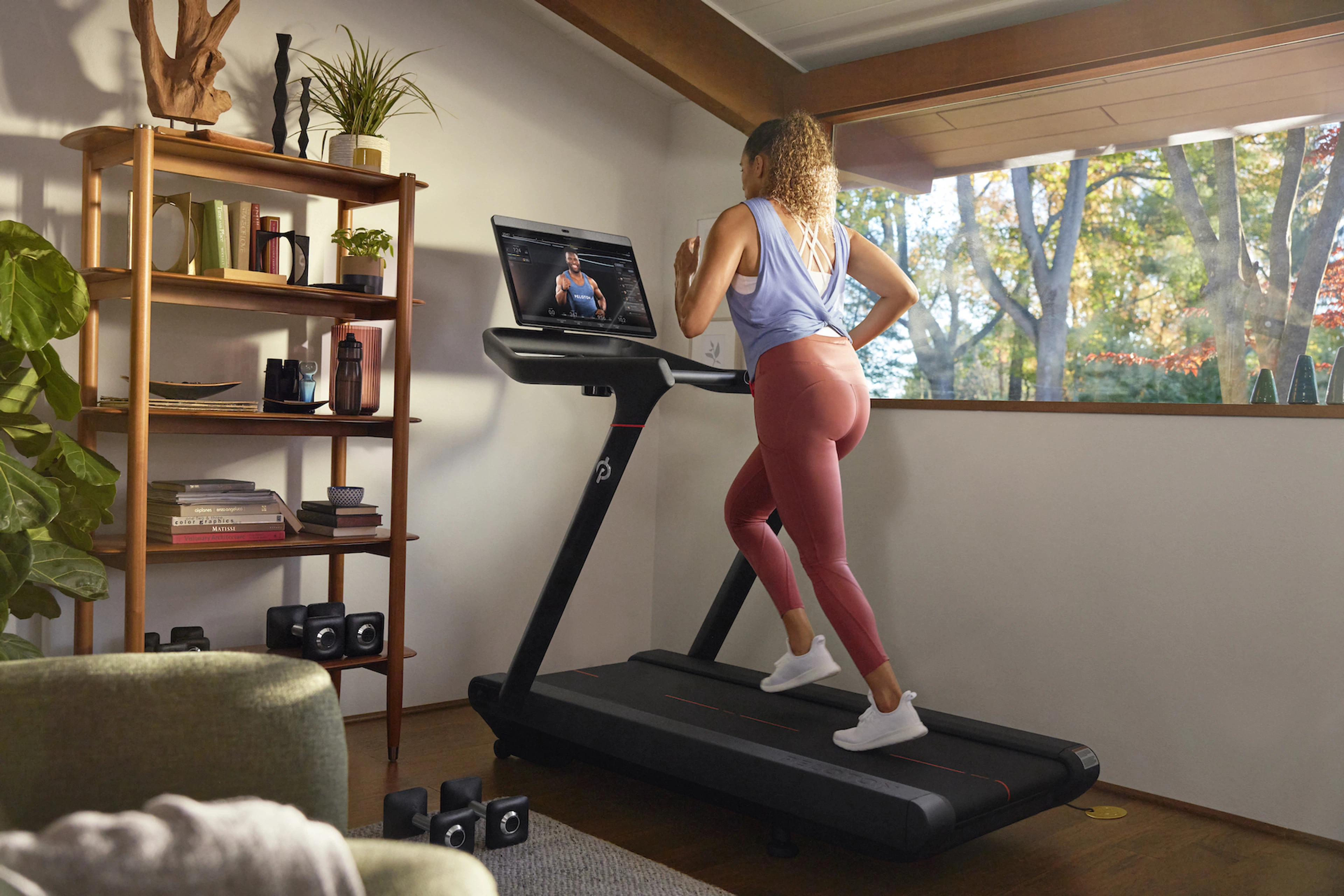 Woman runs on a Peloton Tread at home