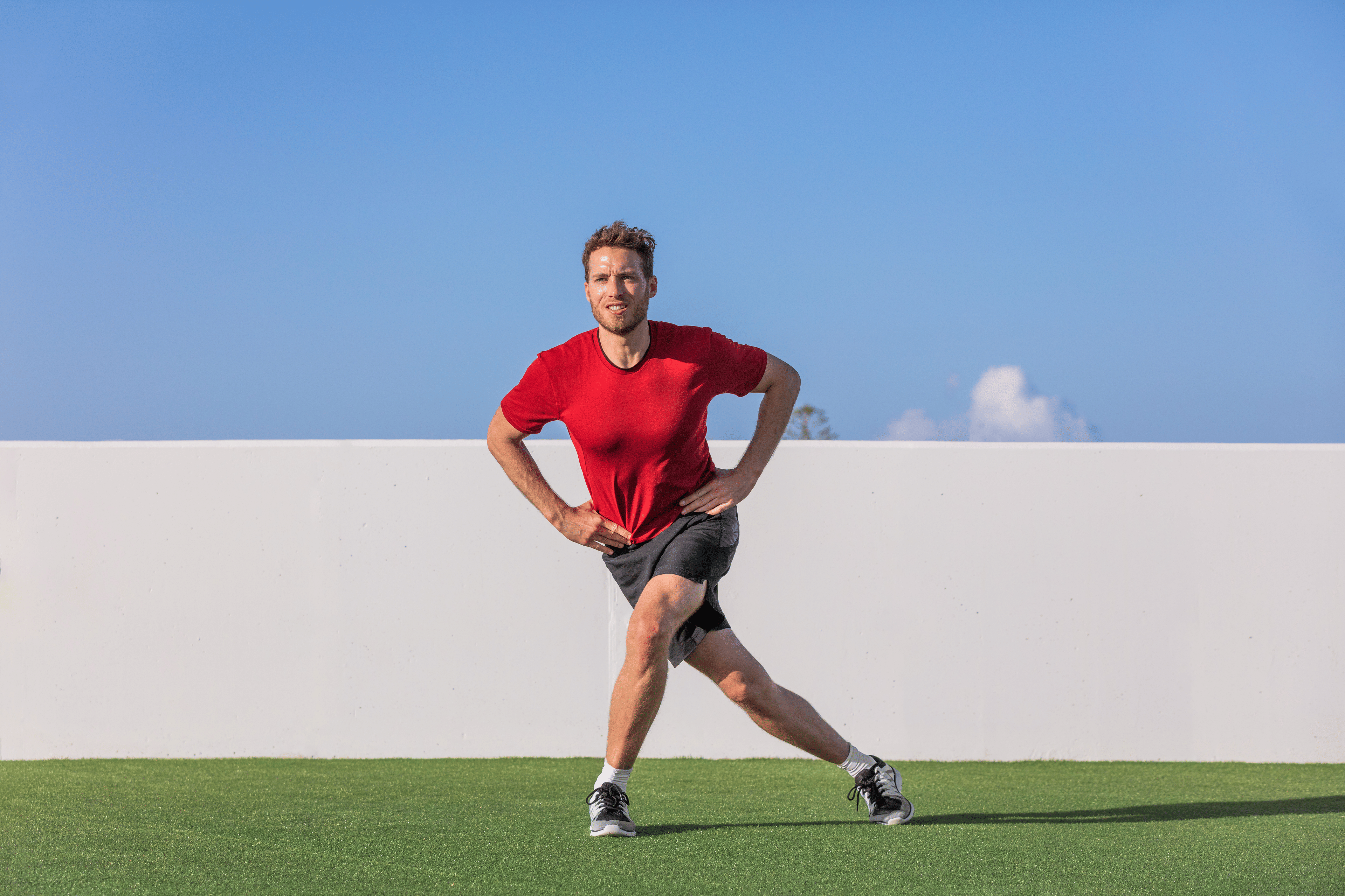 Man practices a curtsy lunge exercise outdoors 