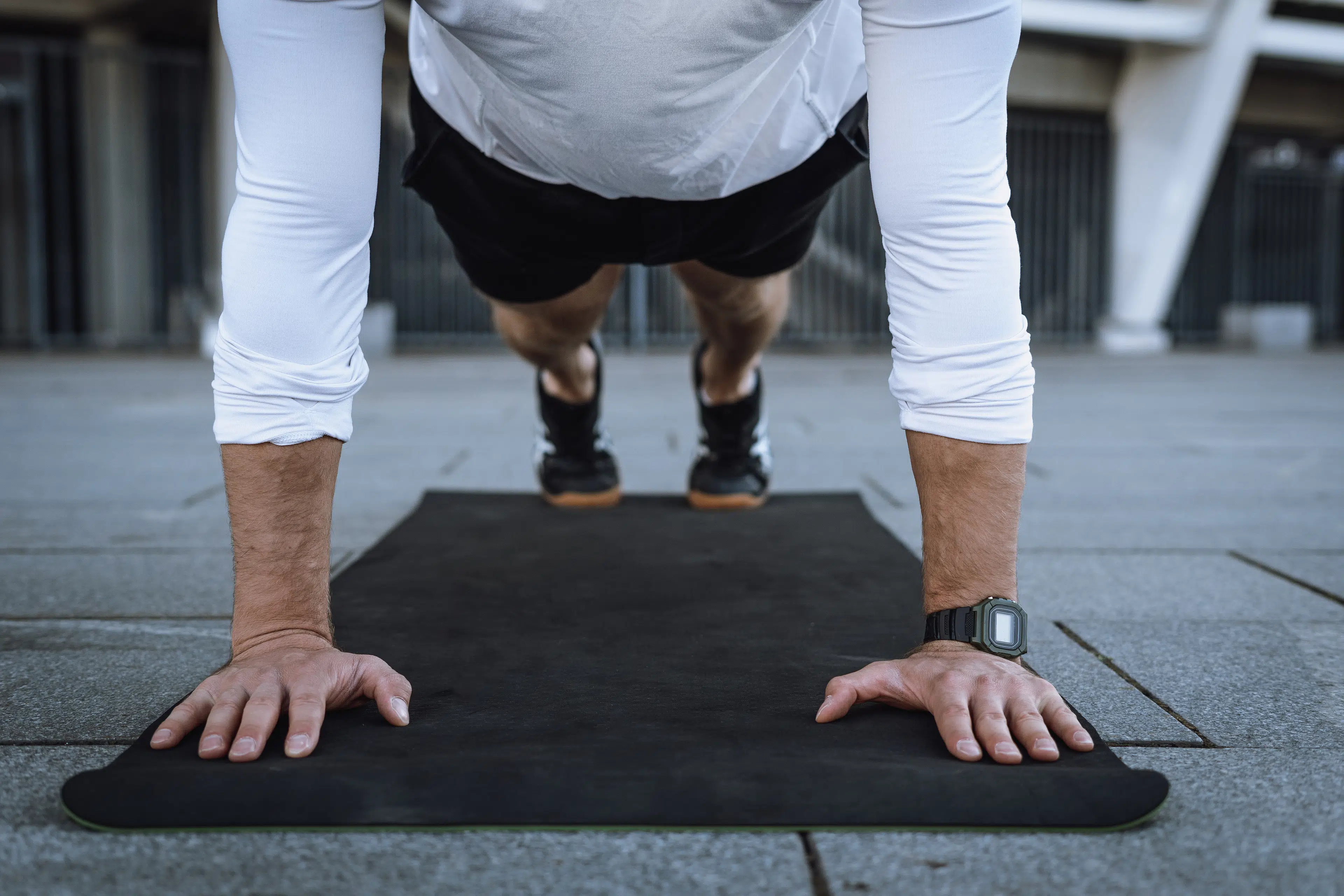 Man in high plank pose on black workout mat 