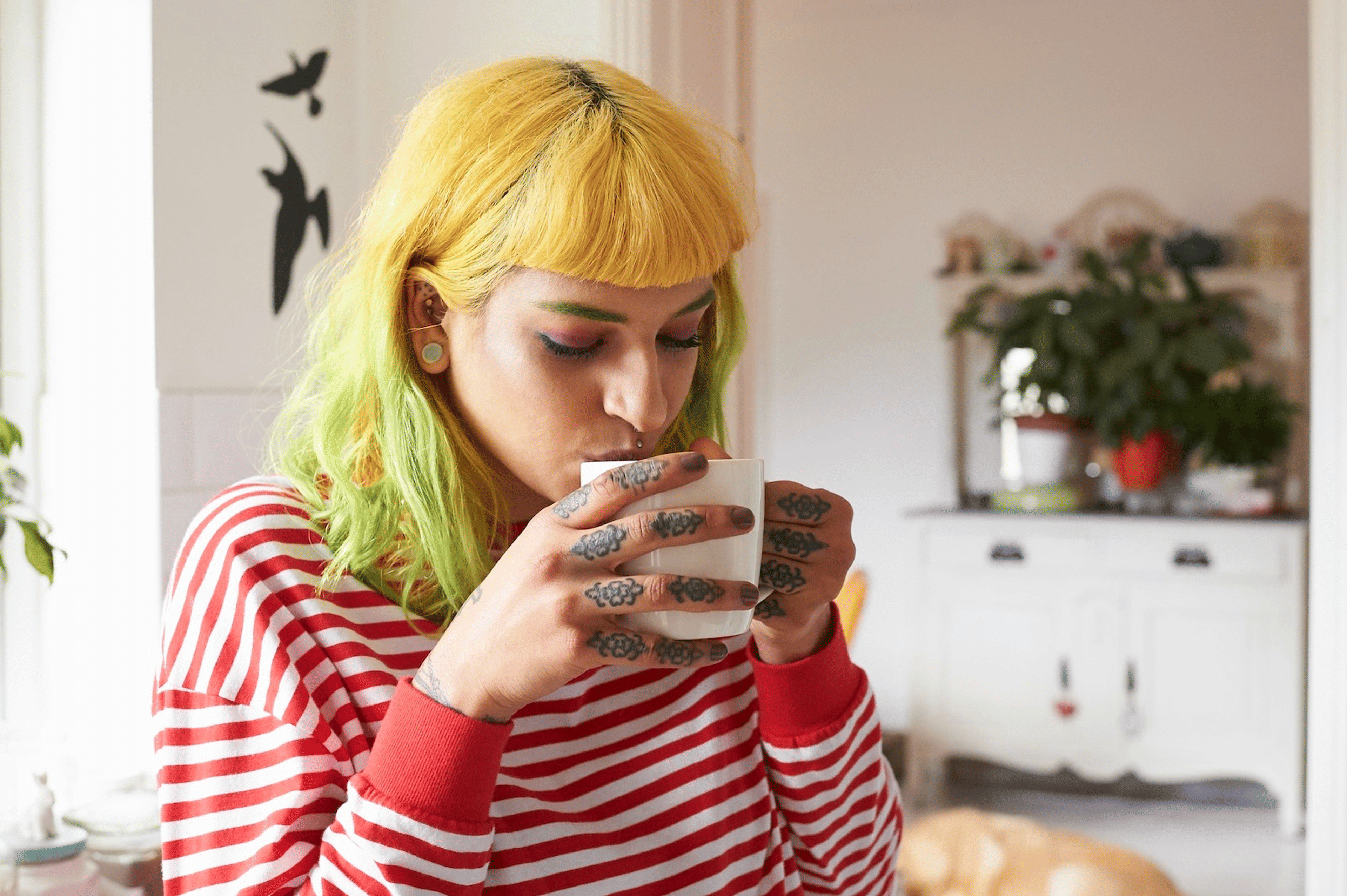 A young woman drinking coffee from a mug.