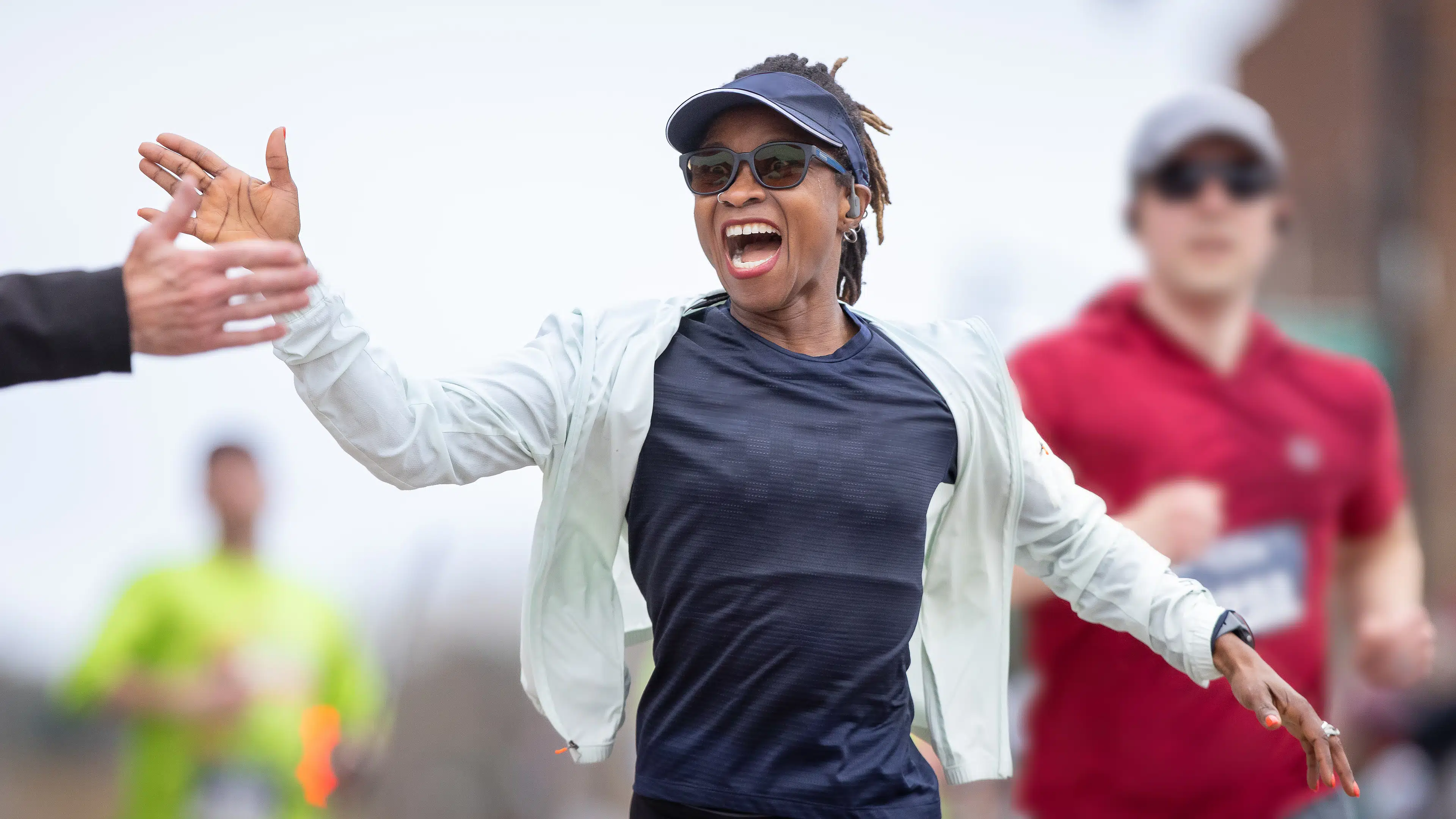 Woman running a marathon high fives a spectator.