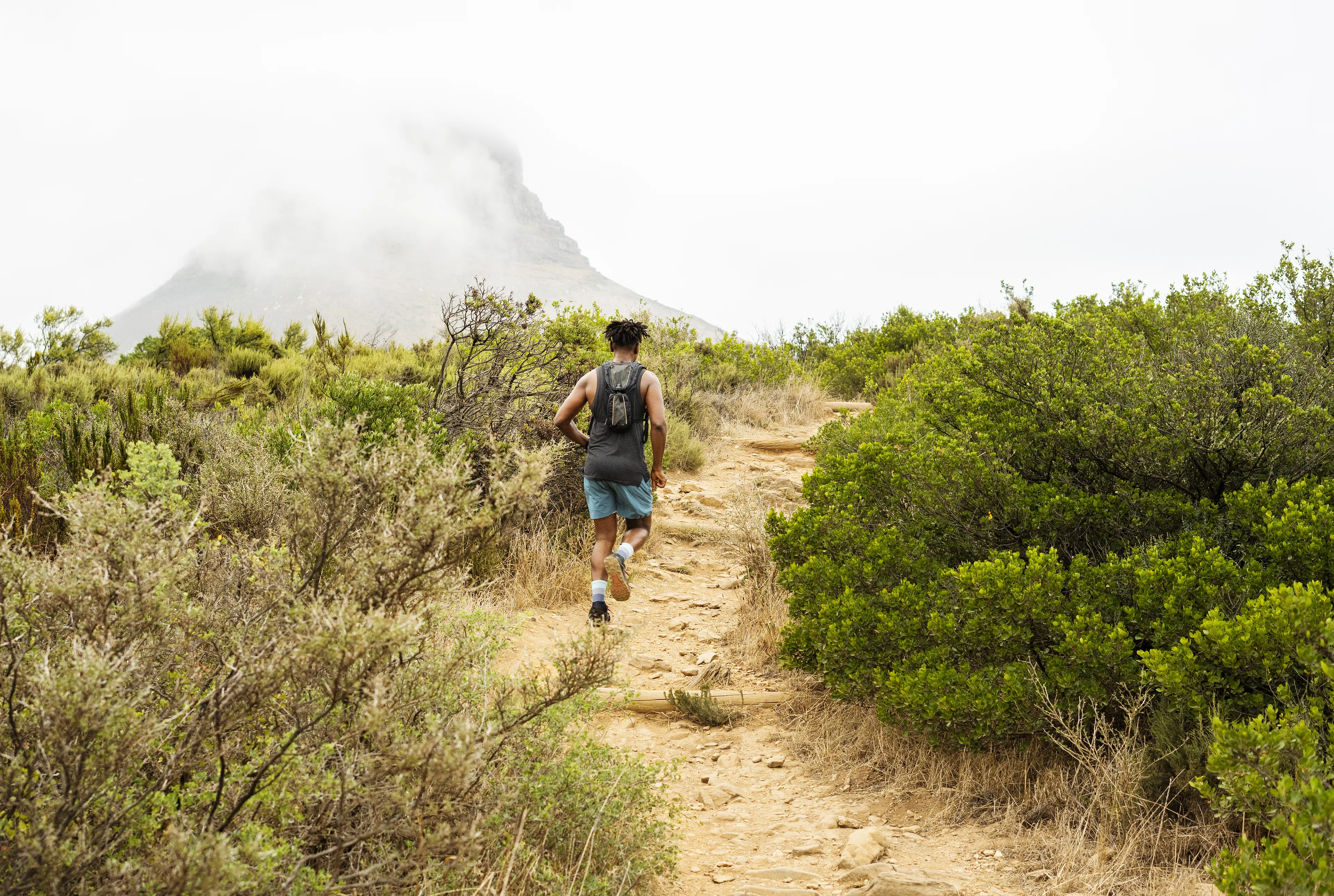 Man doing a scenic trail run on a running vacation as an advanced running goal.