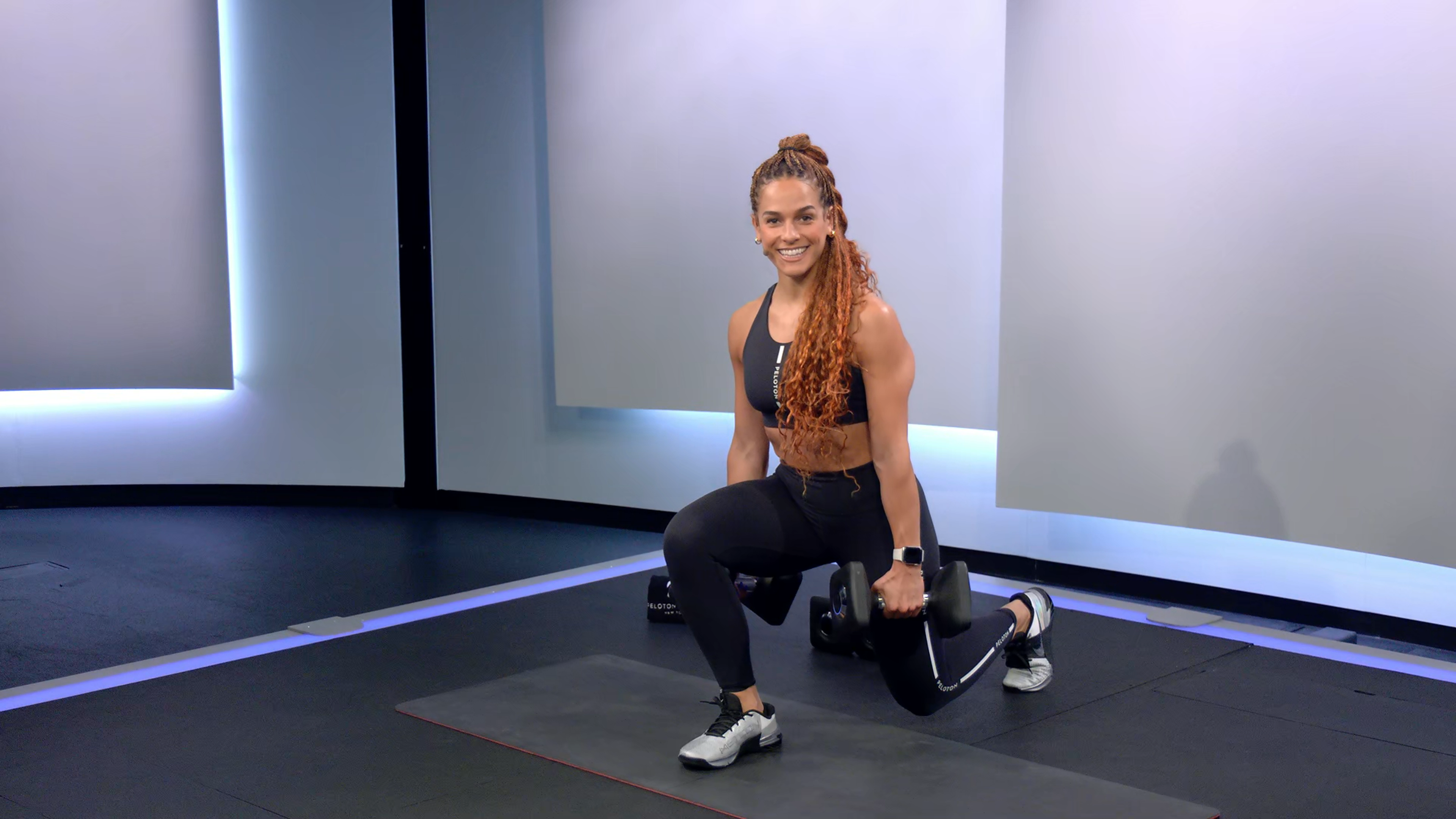 Jess Sims demonstrates a reverse lunge in a Peloton class 