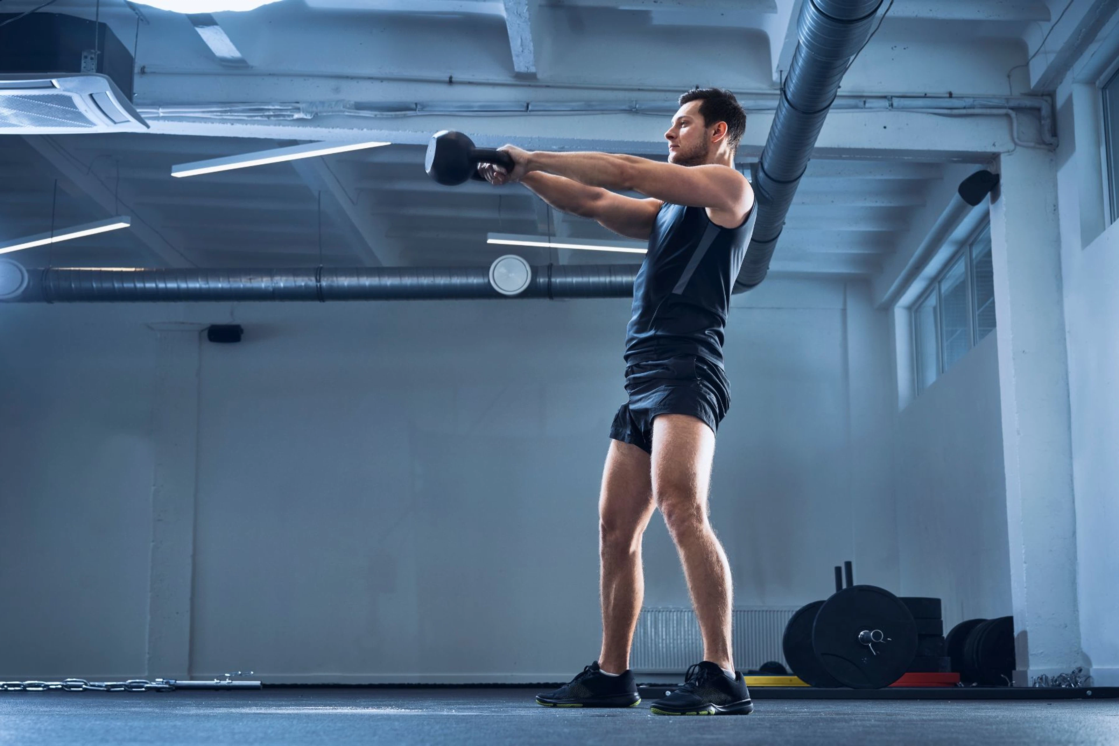 Man doing a kettlebell swing inside
