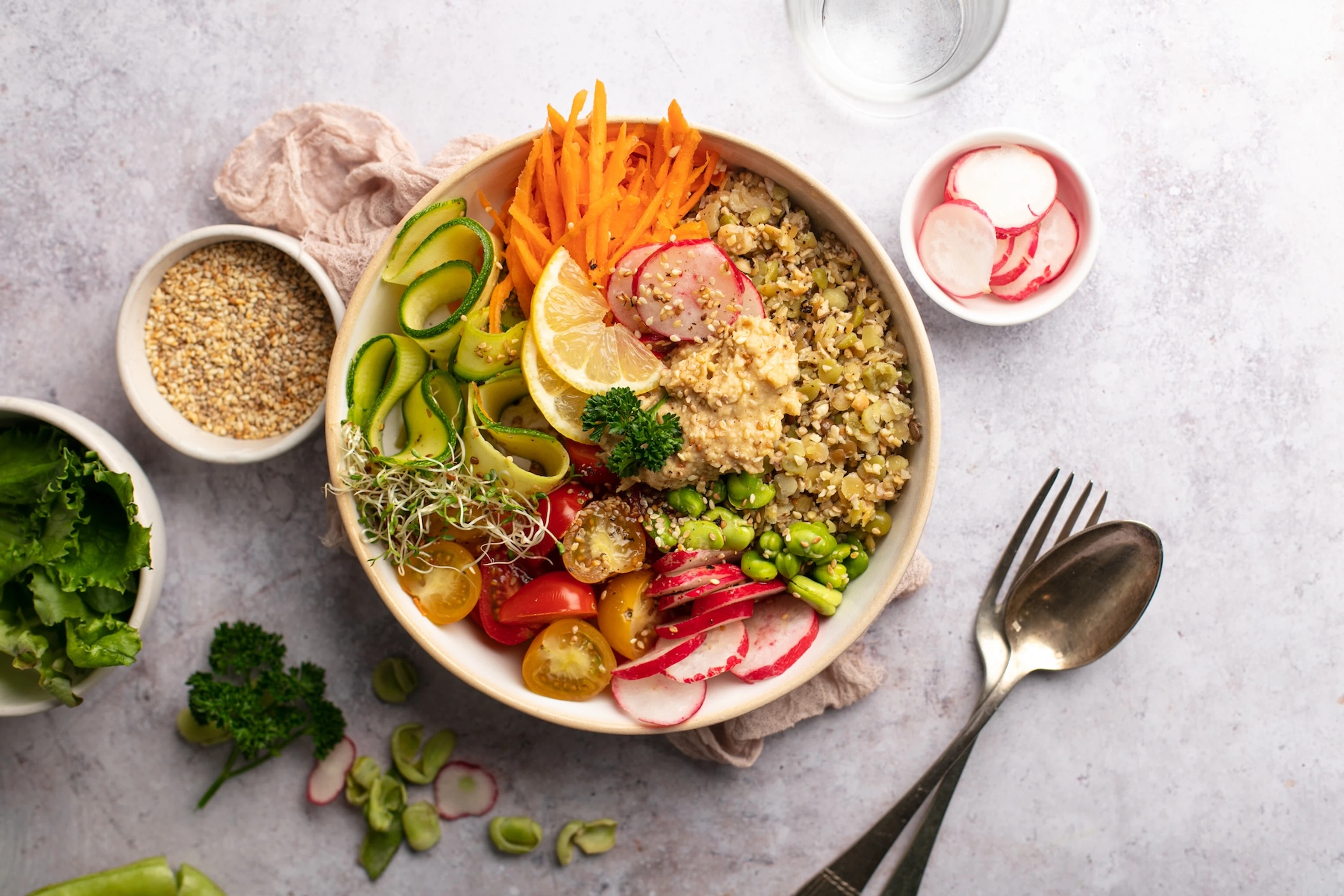 A colorful buddha bowl with non-meat protein sources like quinoa, edamame, and hummus, among other veggies.