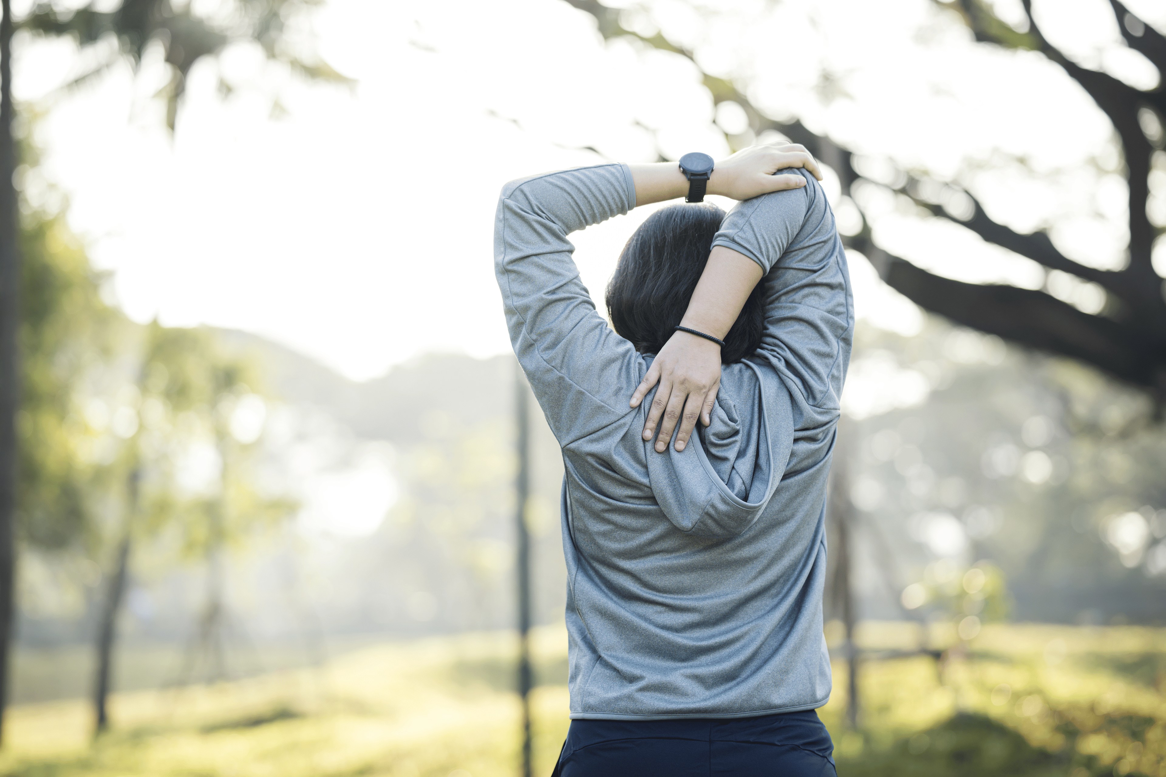 Woman does tricep stretch outdoors