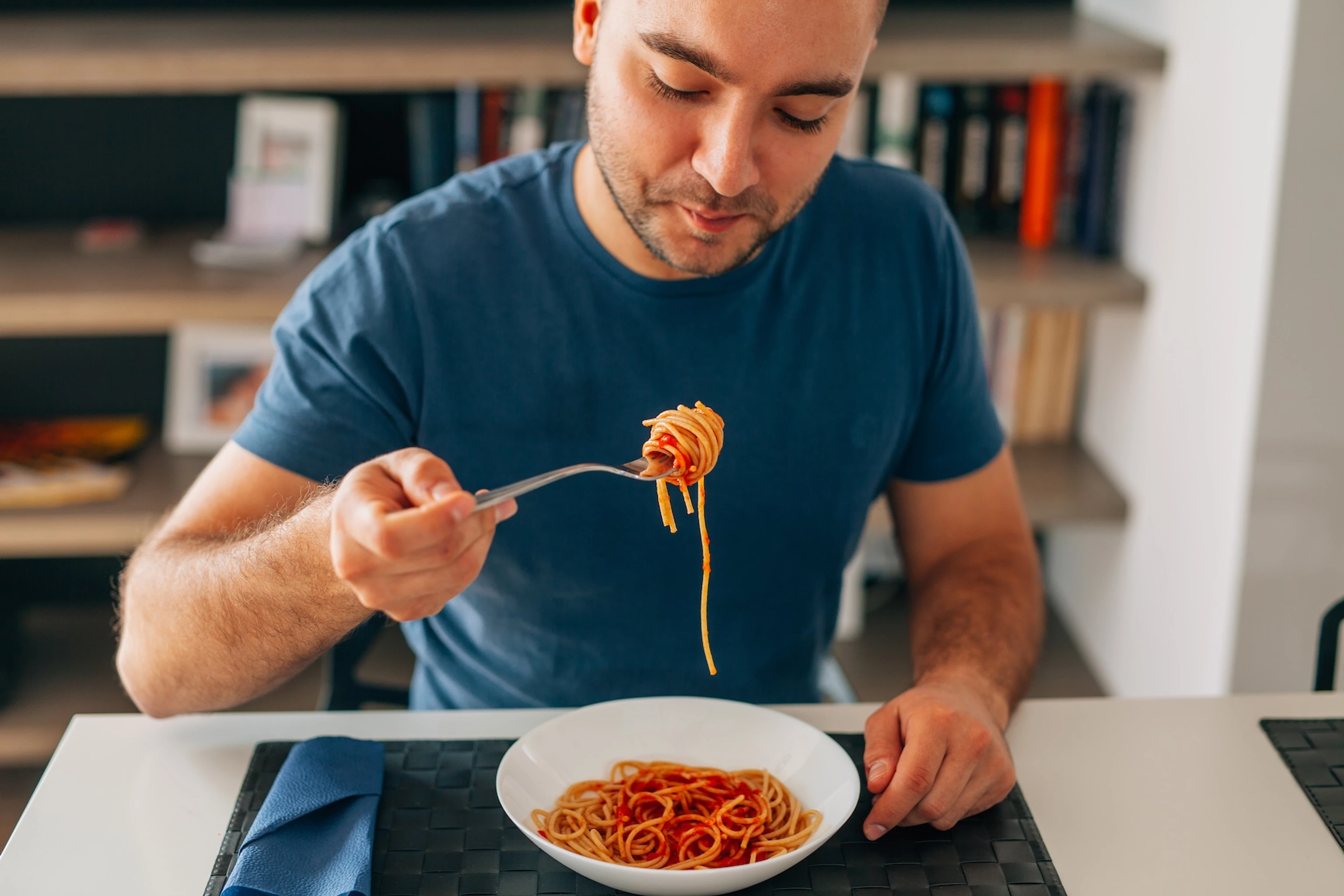 A man eating spaghetti as he carb loads.