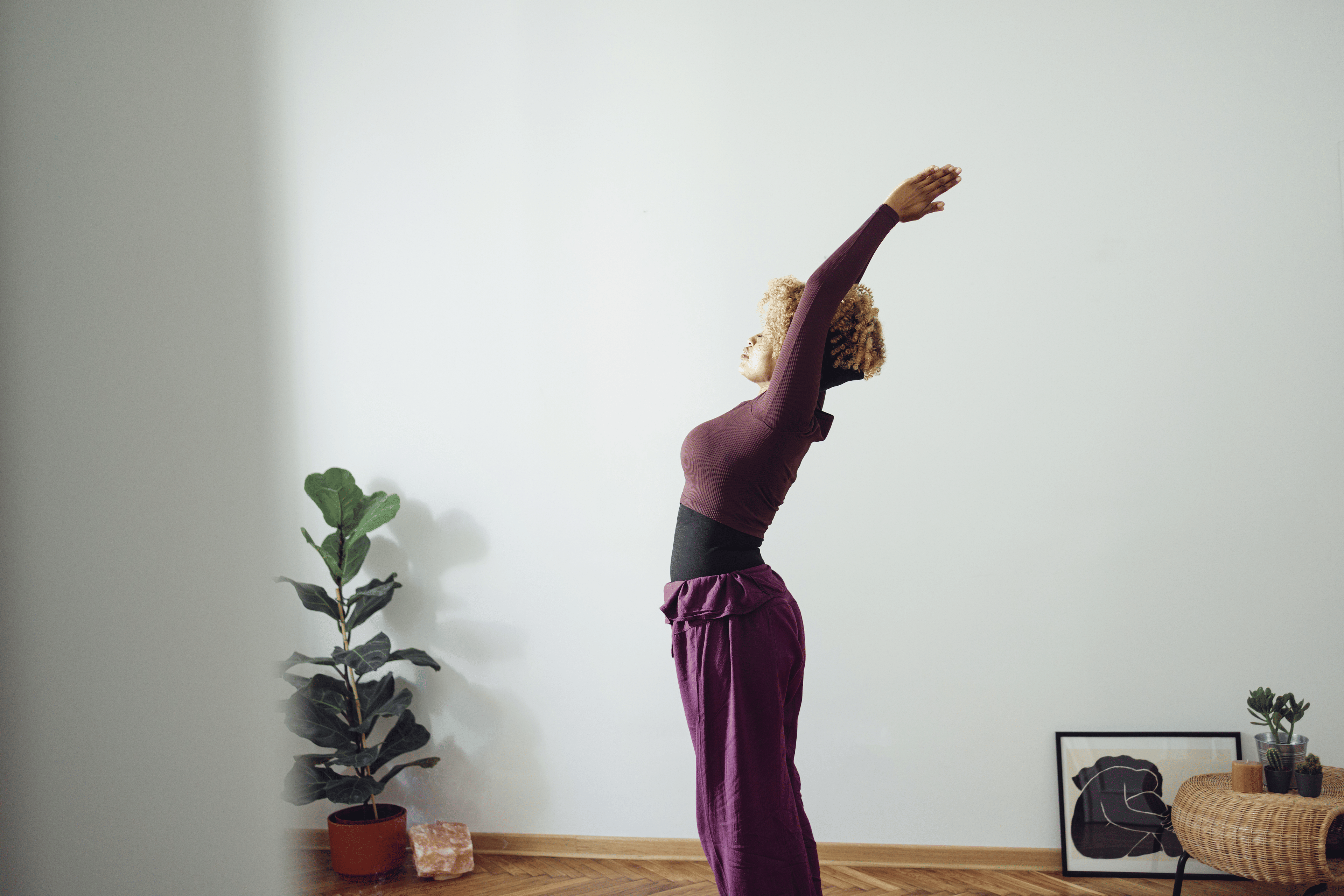 Woman does morning stretches in bright morning light at home