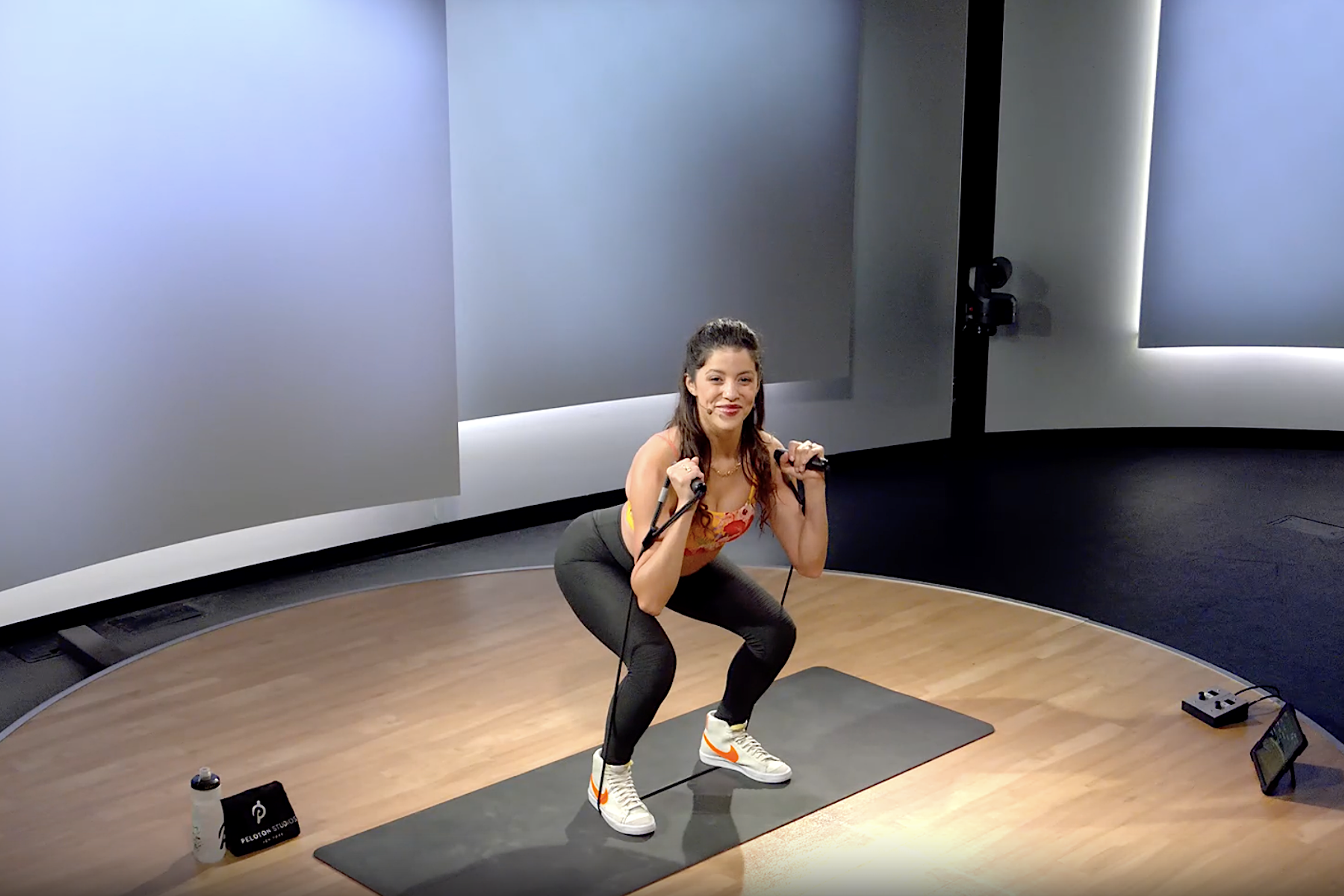 Peloton instructor Hannah Corbin doing a resistance band squat exercise.