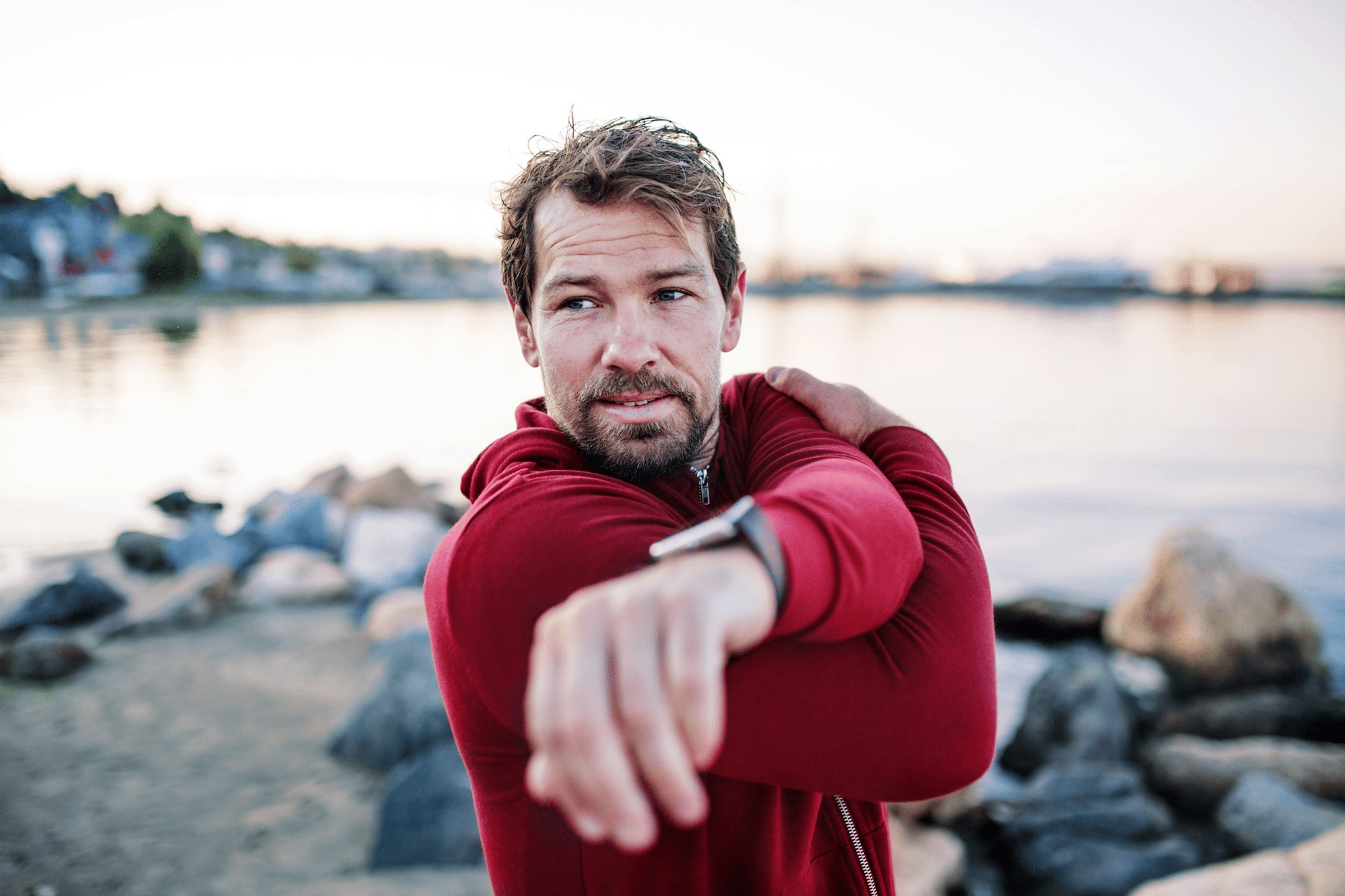 A man prioritizing his healthspan by stretching before exercising outside.