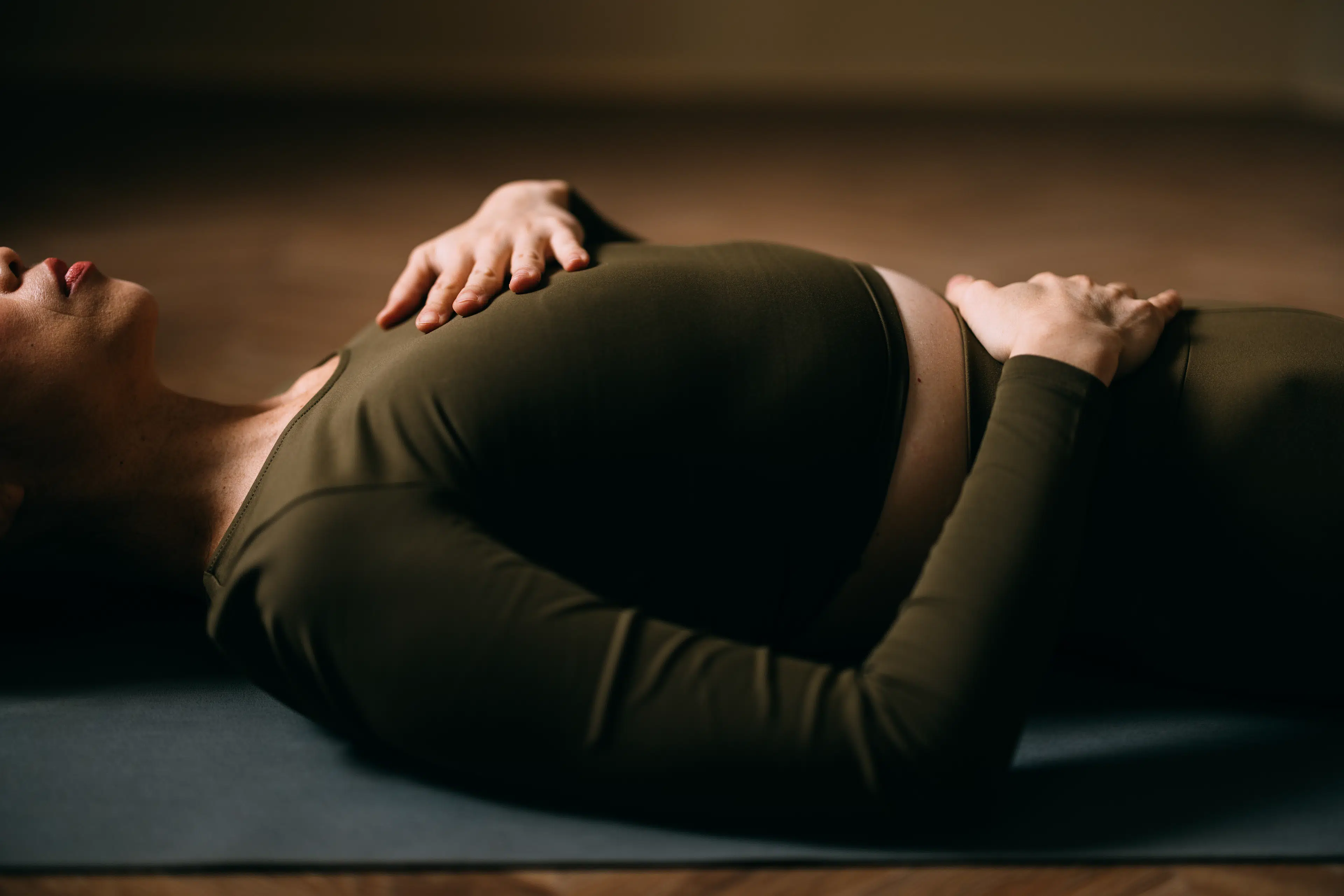 Photo of woman's torso as she reclines on the floow in Savasana yoga pose 