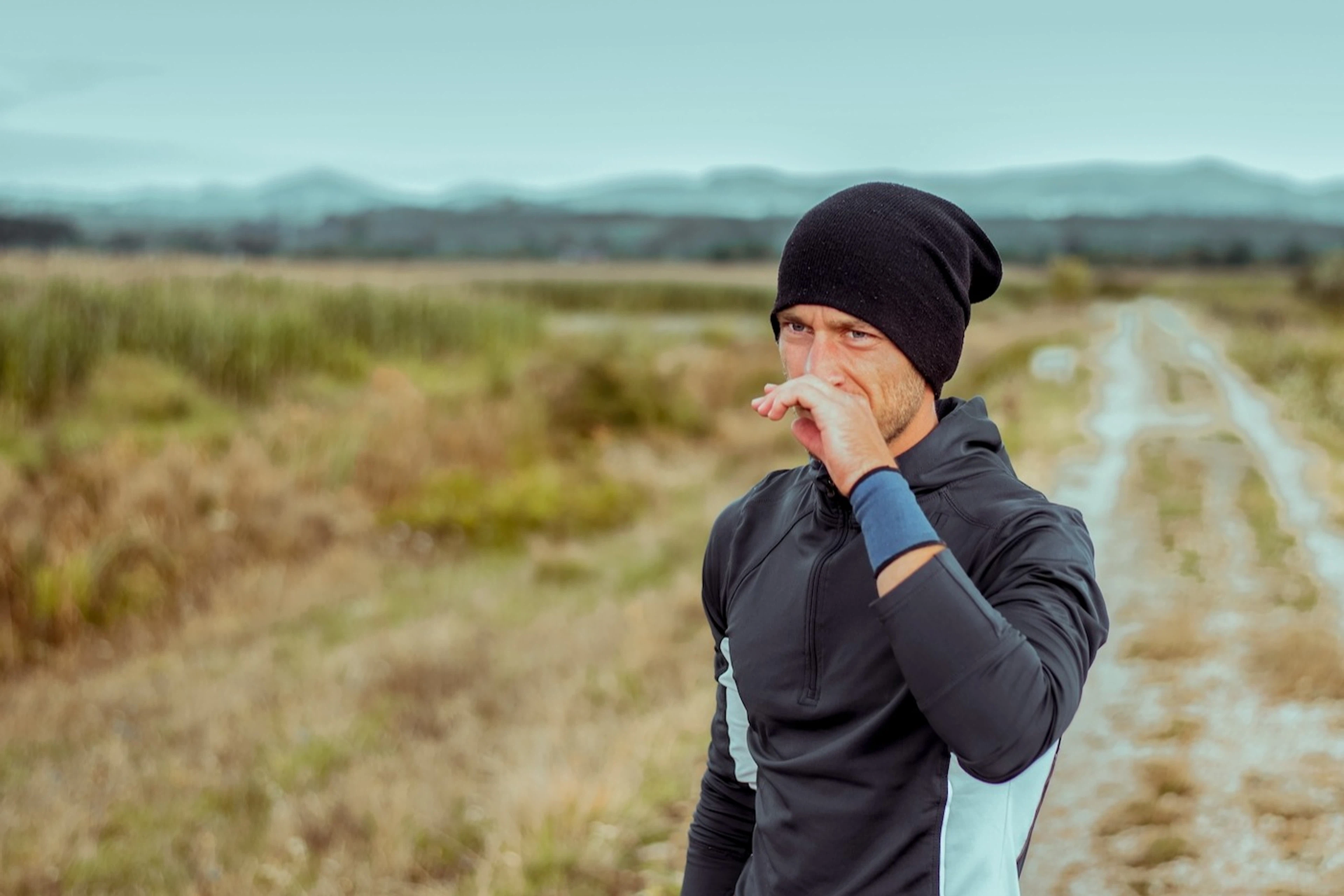 A man experiencing a runny nose when exercising outside.