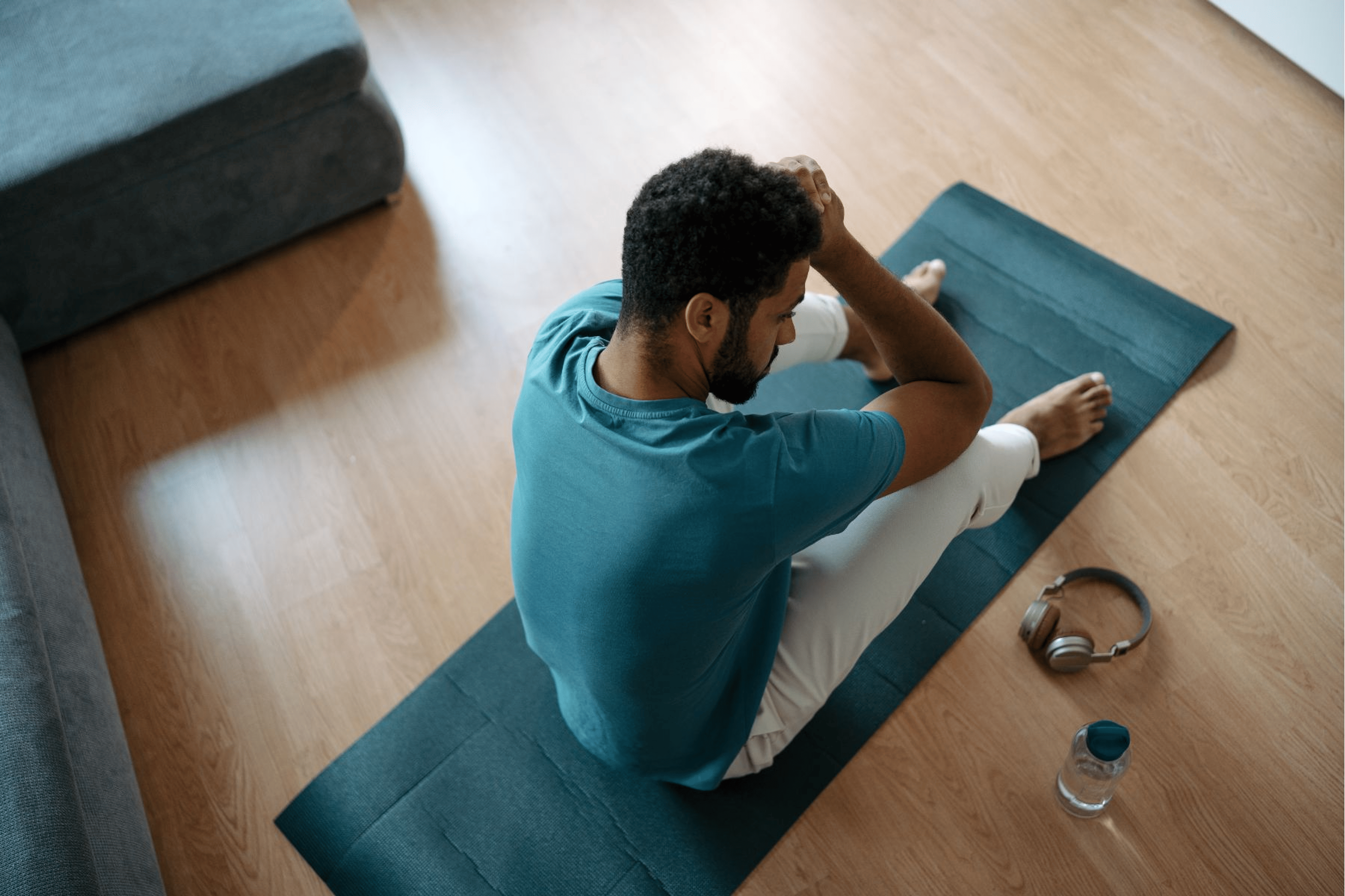 Tired man sitting on a yoga mat