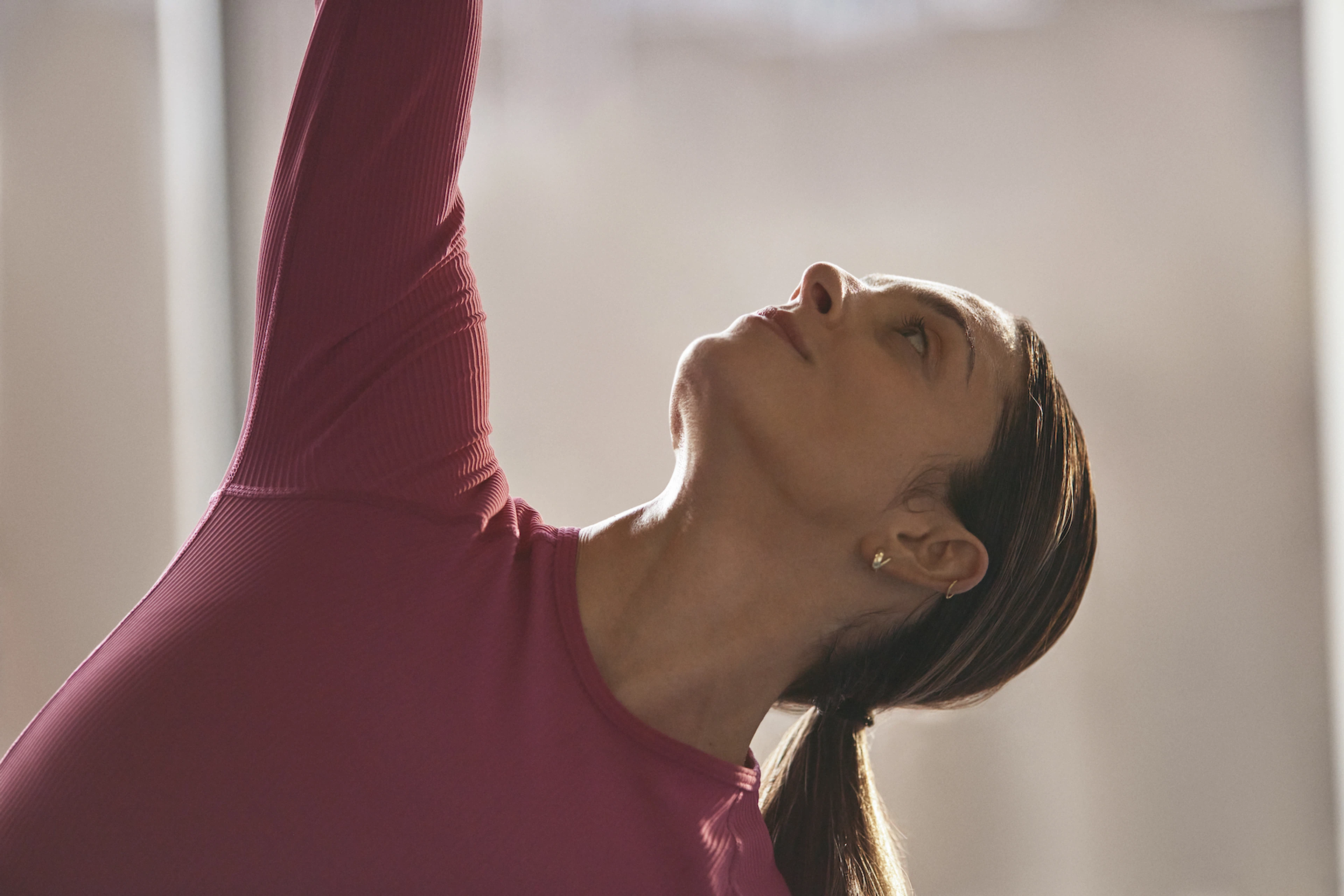 Woman stretches while looking up 
