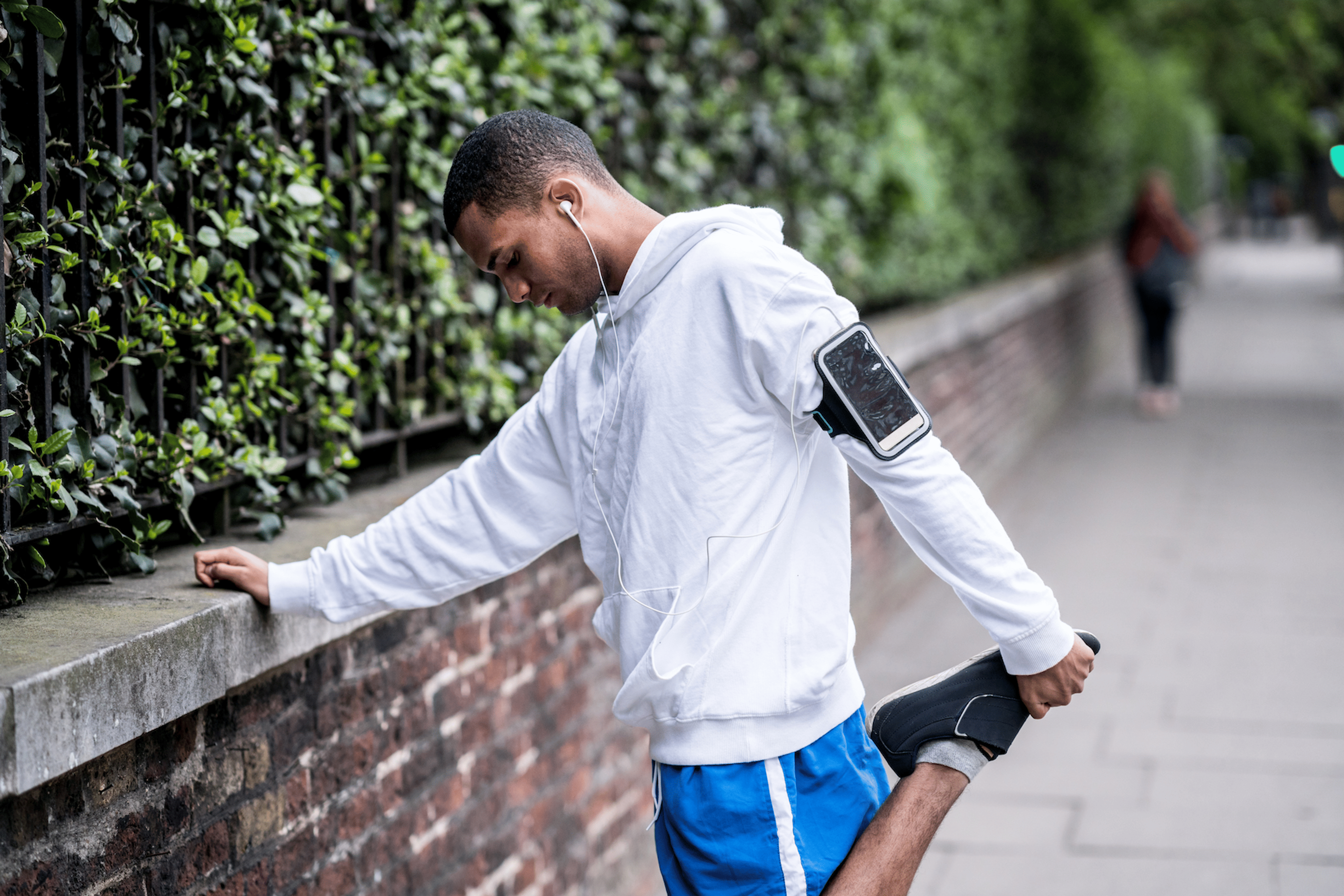 Man does an it band stretch before heading out on a run