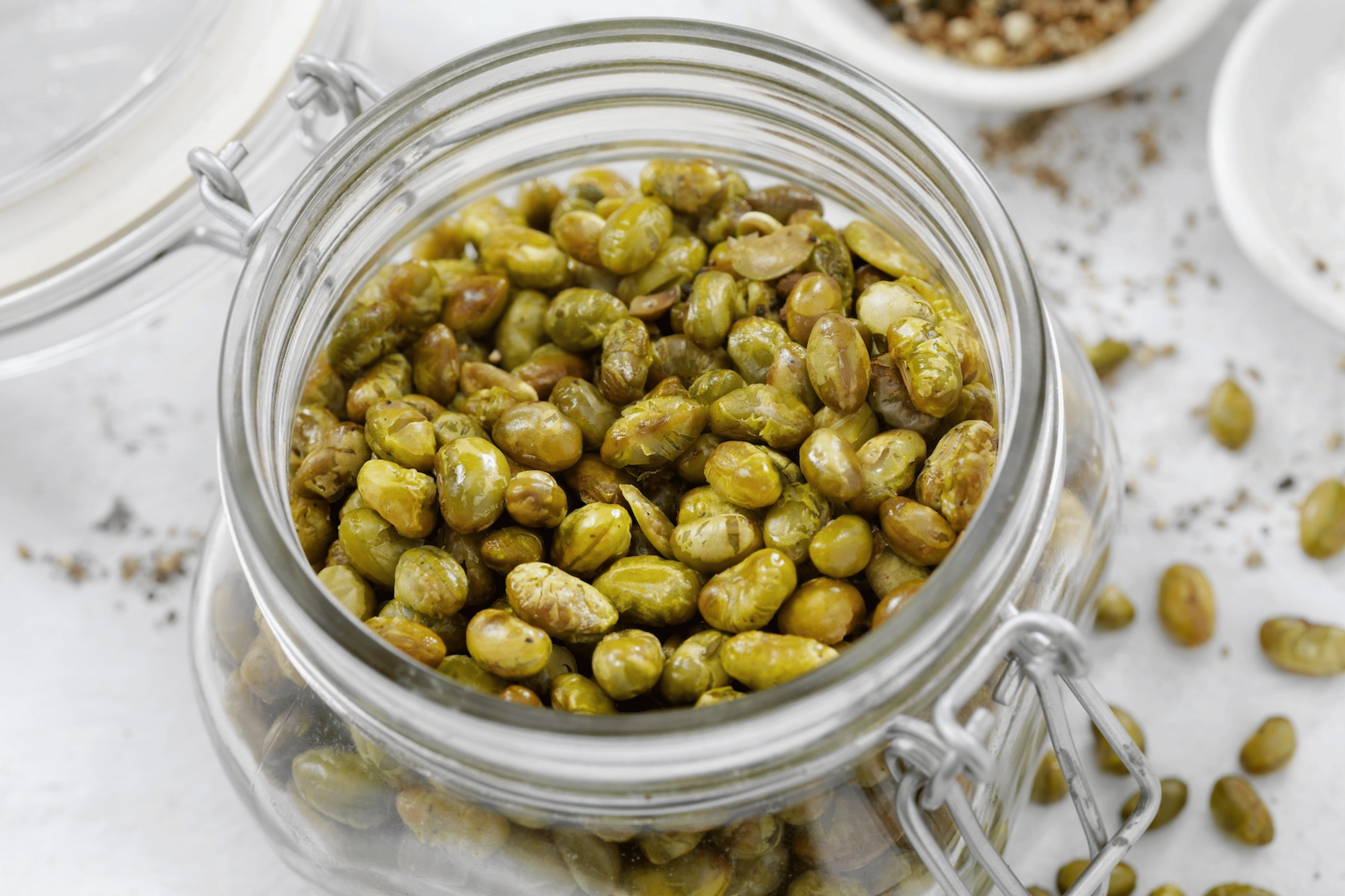 A glass bowl of dry-roasted edamame, which is a high-protein snack.