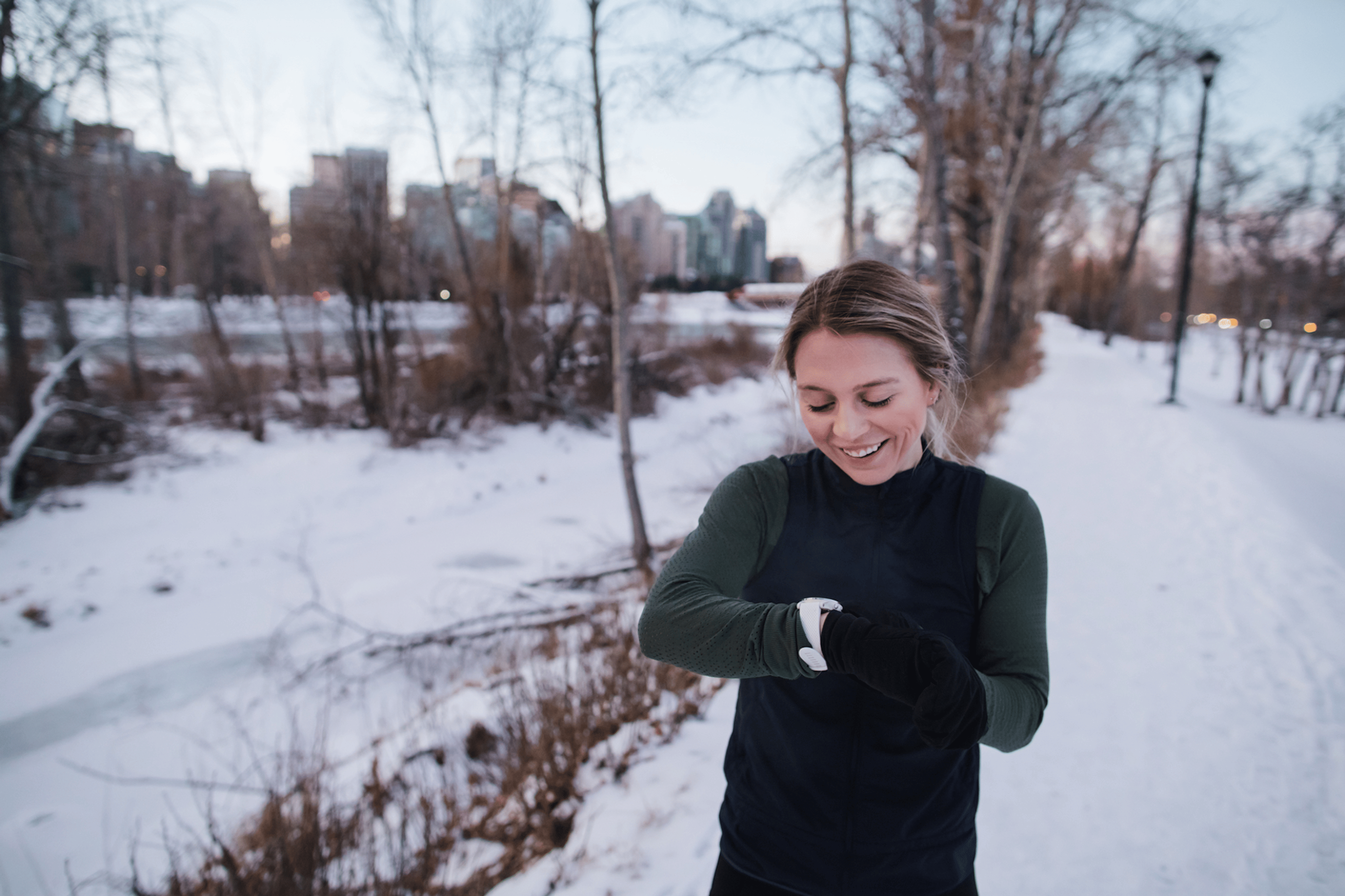 Woman checks her watch on a cold-weather run