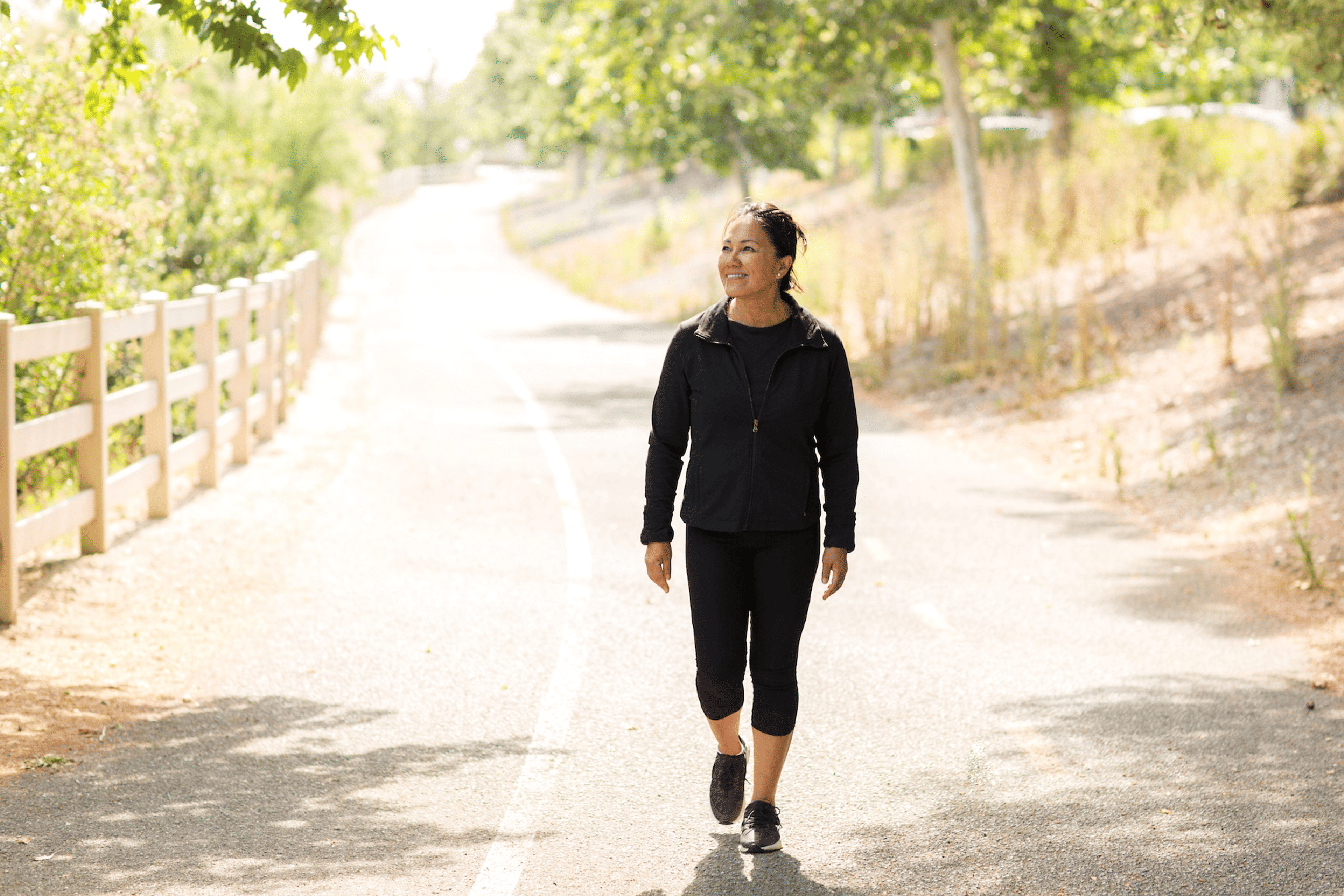 A woman practicing a healthy habit by going for a walk outdoors.