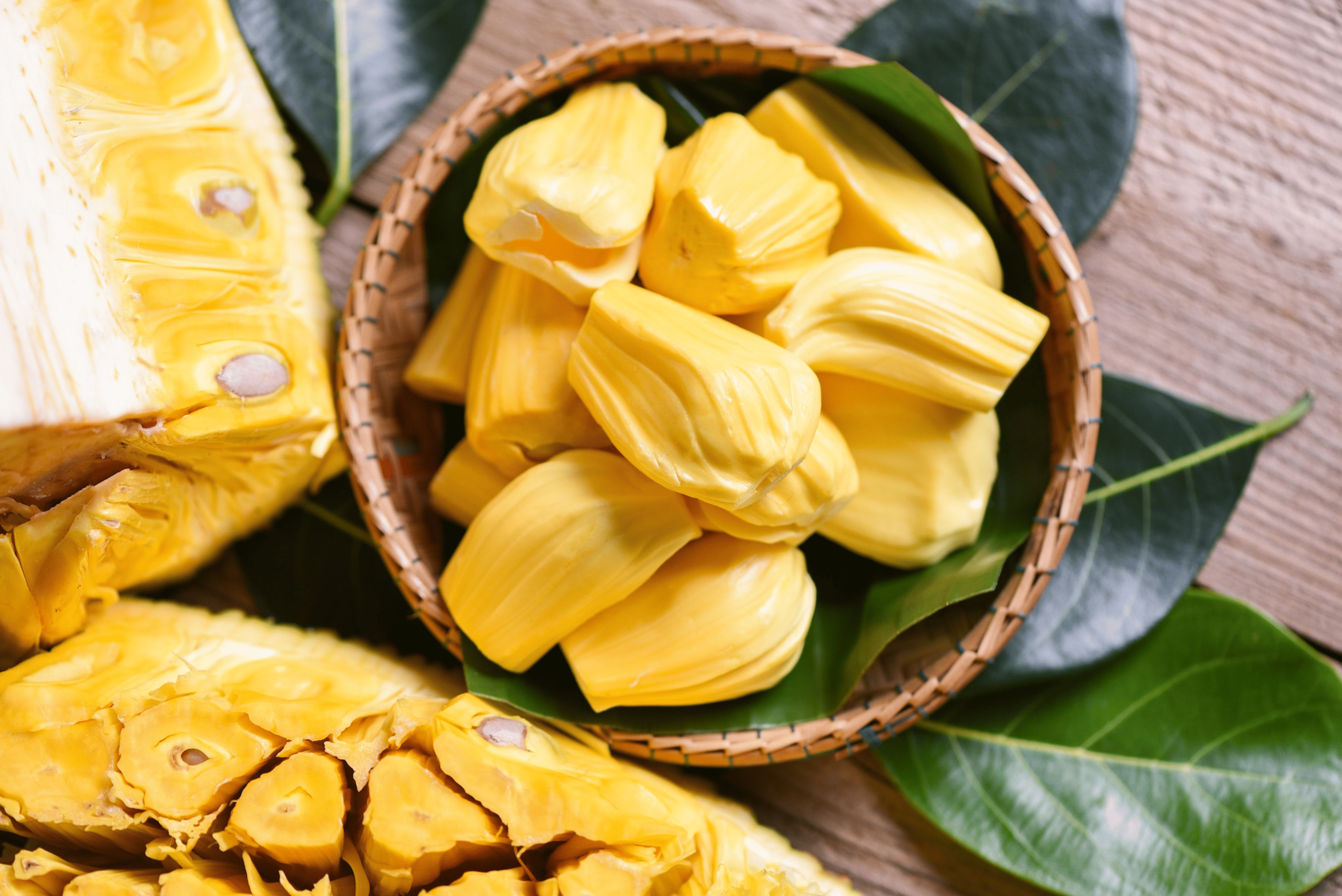 A wooden basket filled with ripe peeled jackfruit, which is a high-protein fruit.
