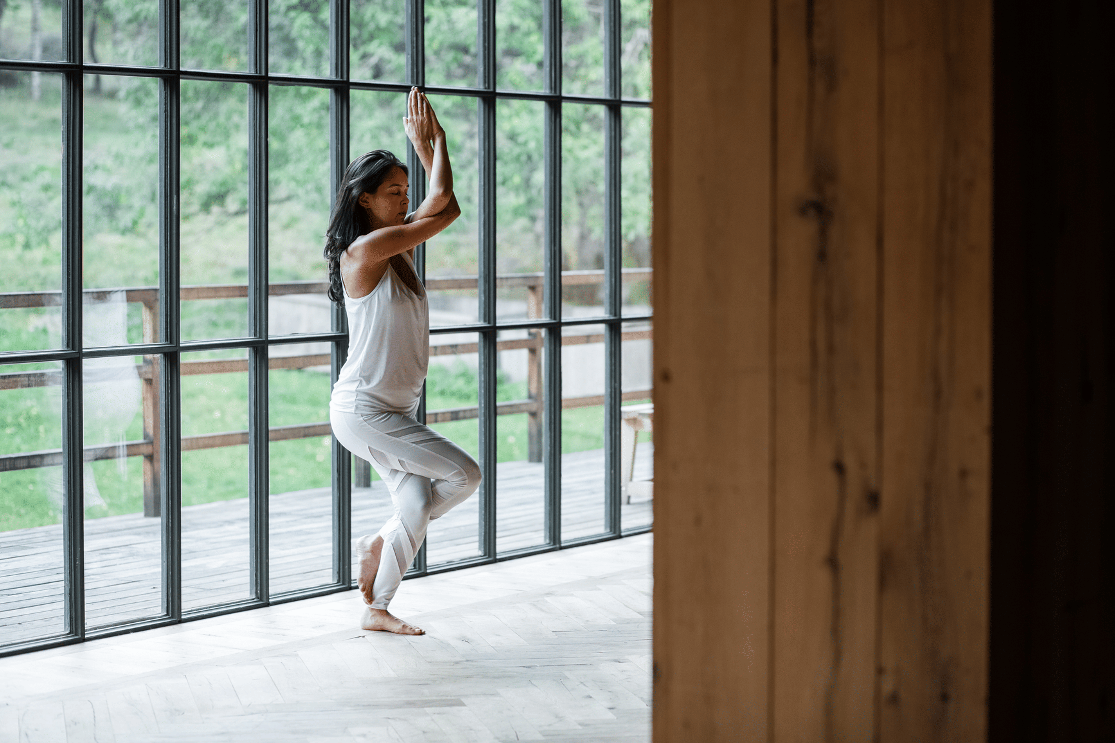 Photograph of woman doing Eagle Pose in yoga clothing