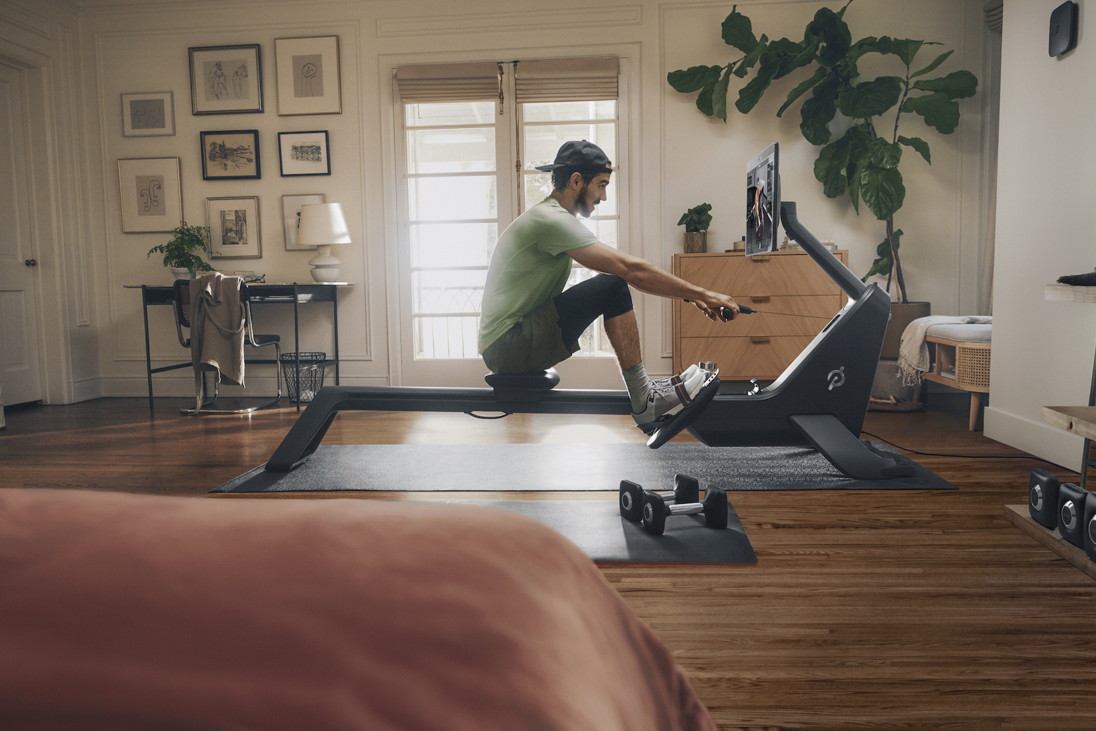 Image of man rowing on Peloton Row machine 