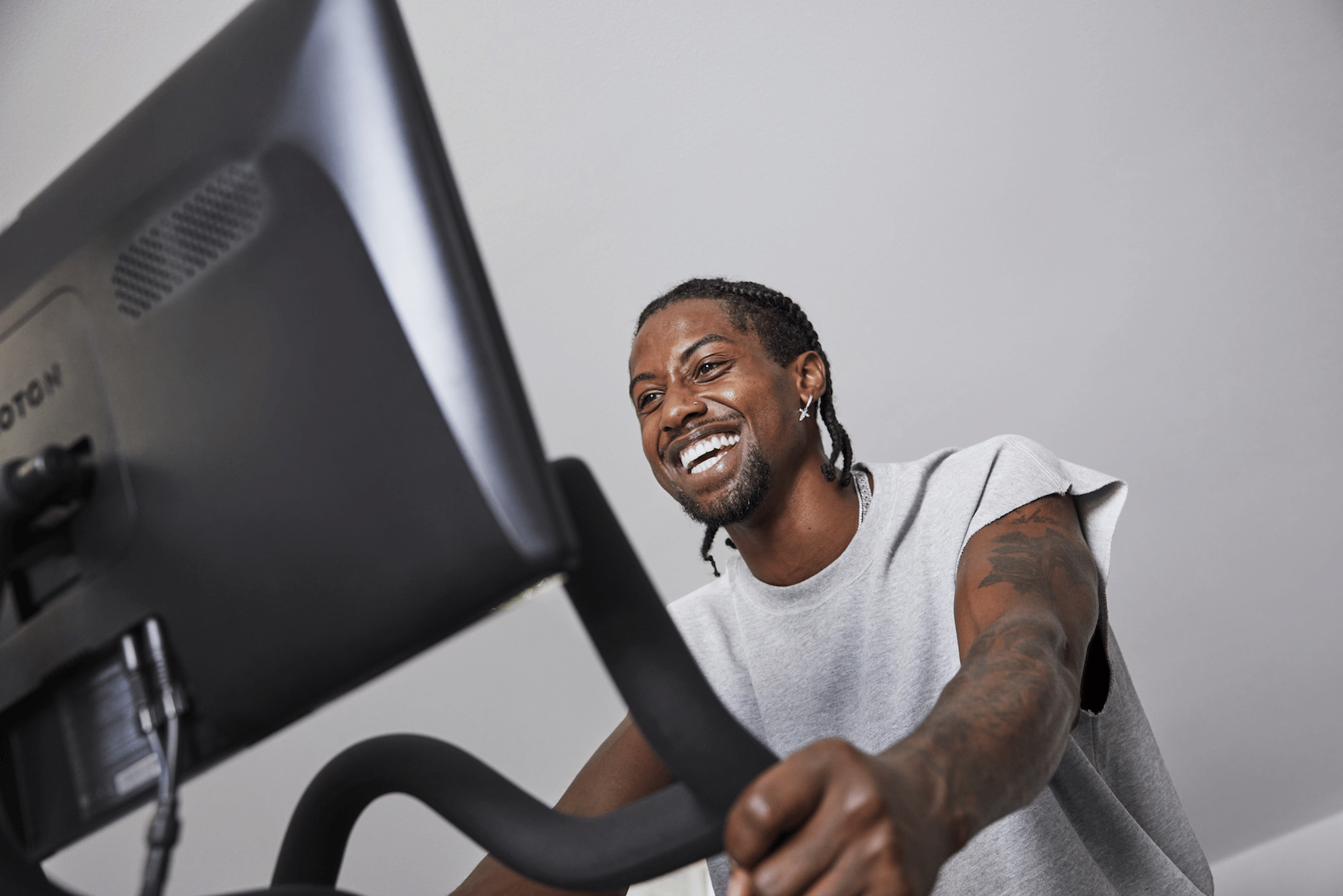 A man happily trying new things by riding on his Peloton Bike.
