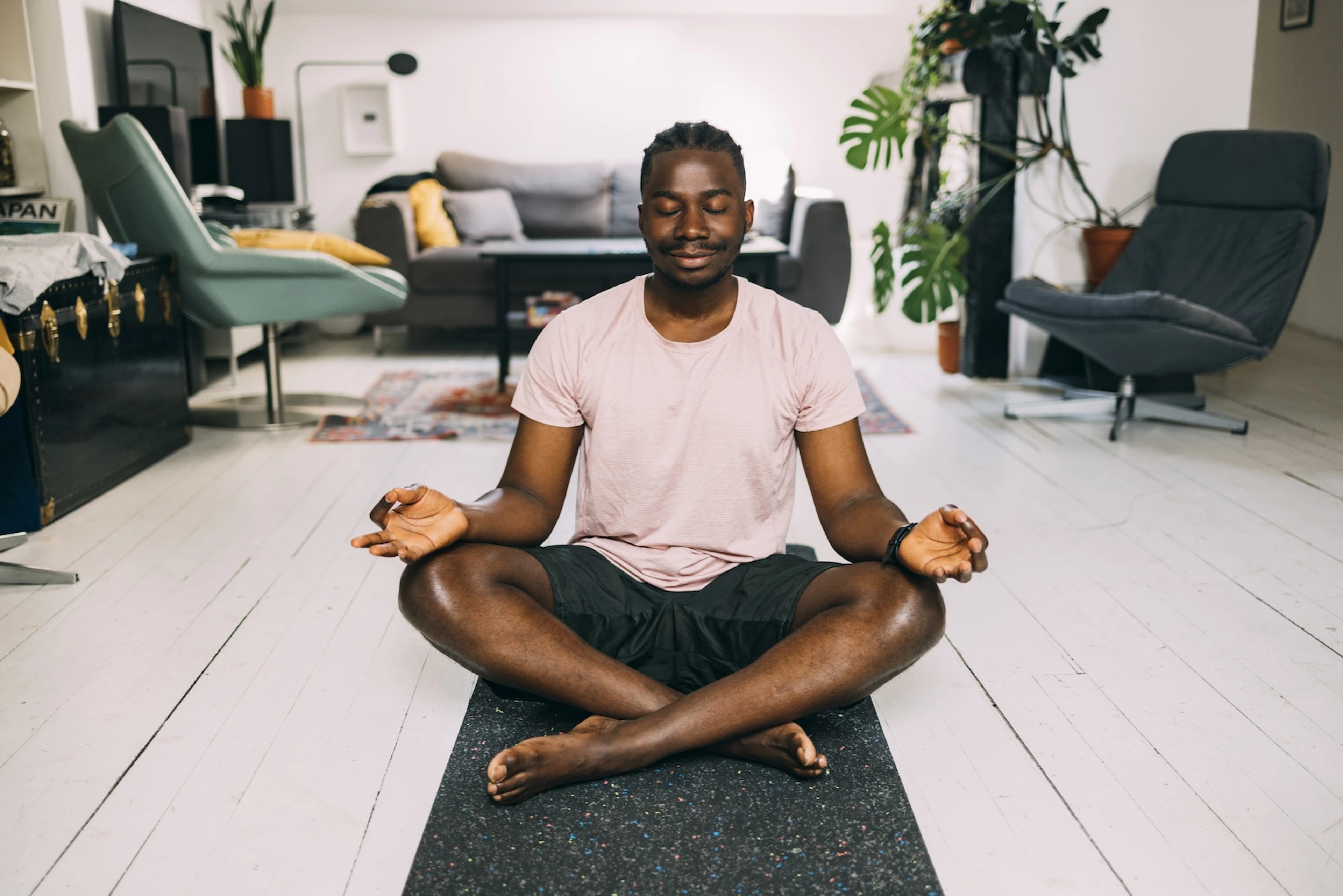 A man meditating at home on a rest day.