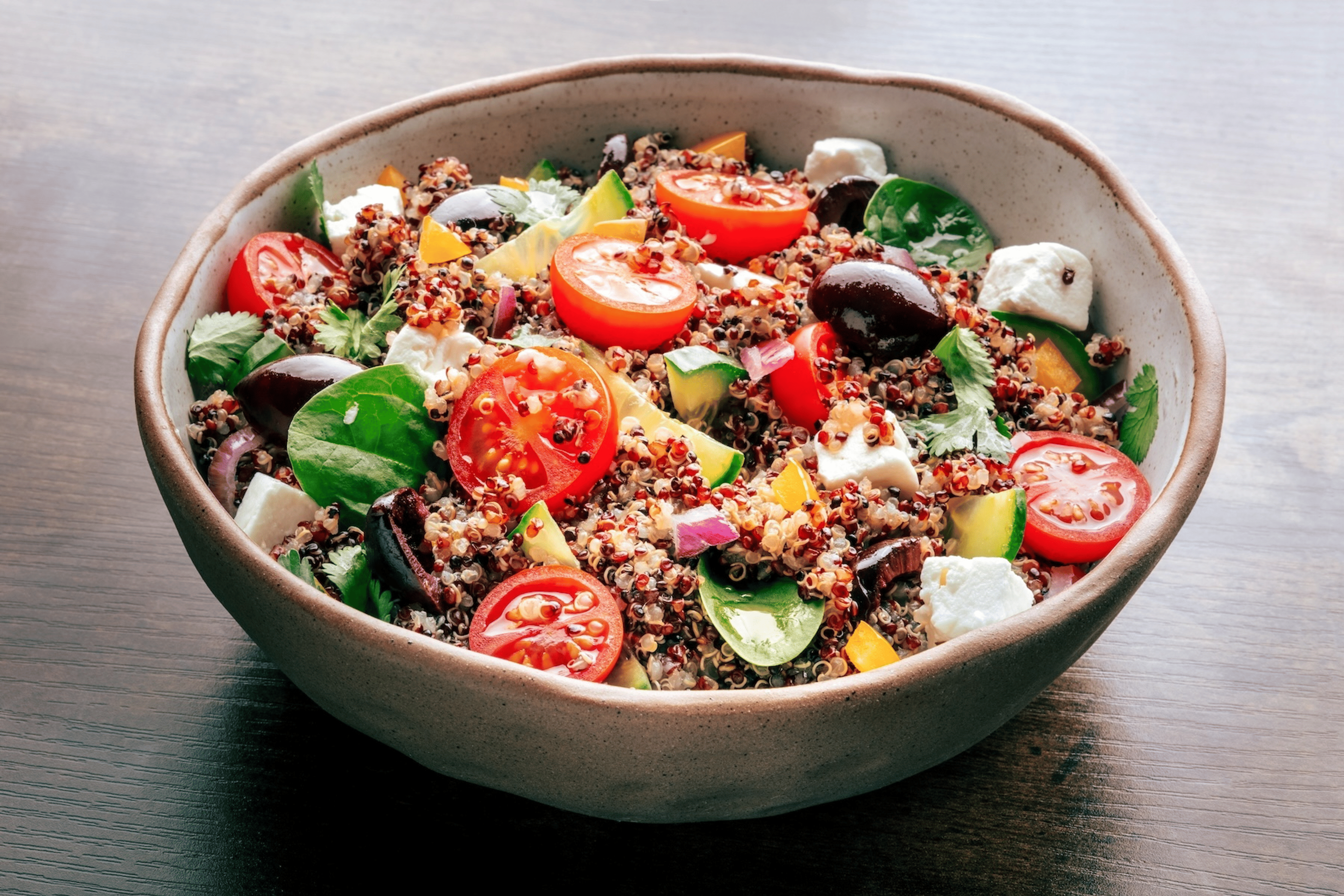 A salad made with quinoa (a non-meat protein source) and tomatoes, cheese, olives, and other veggies.