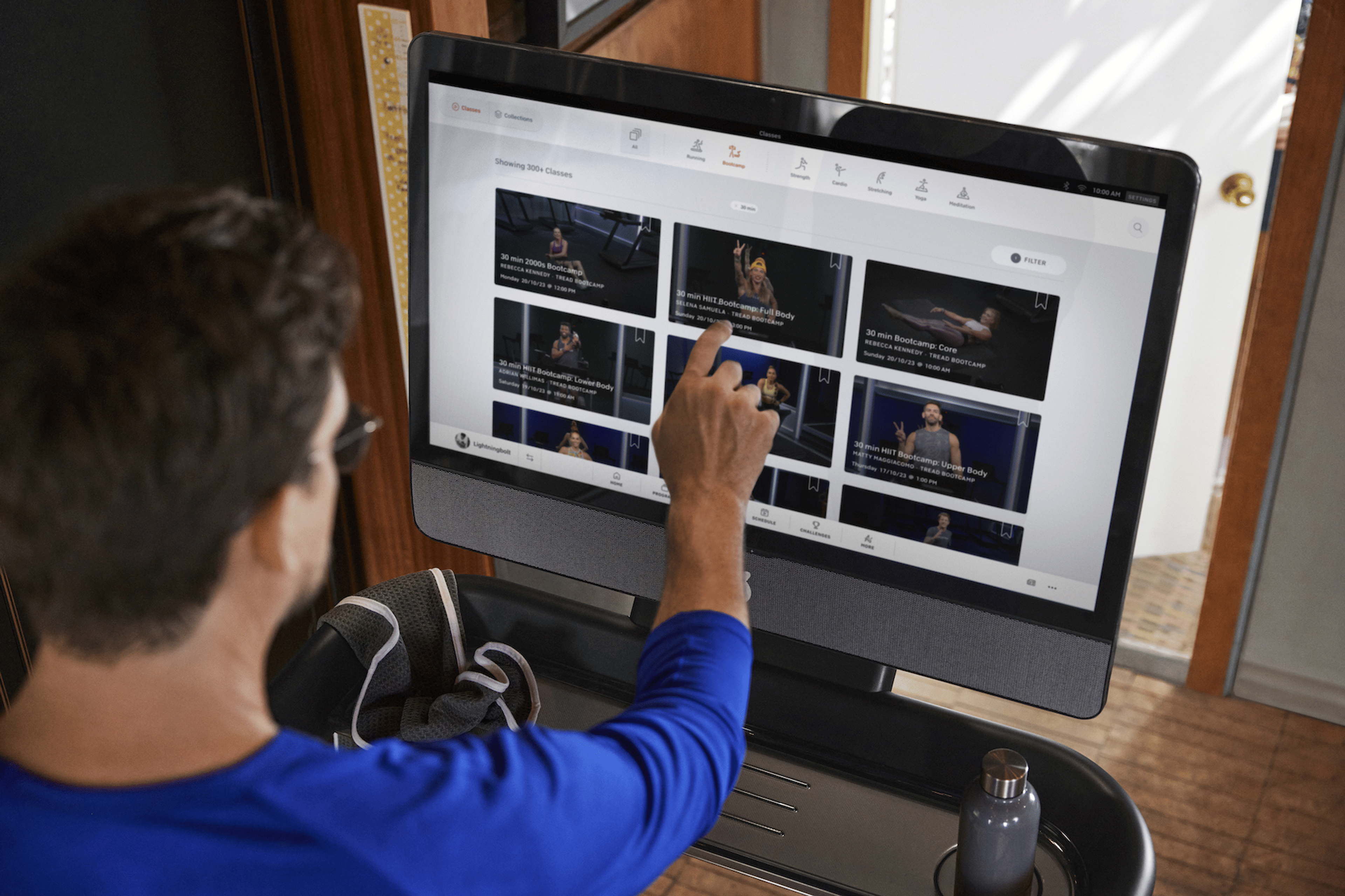 Man looks at classes to take on the Peloton Tread