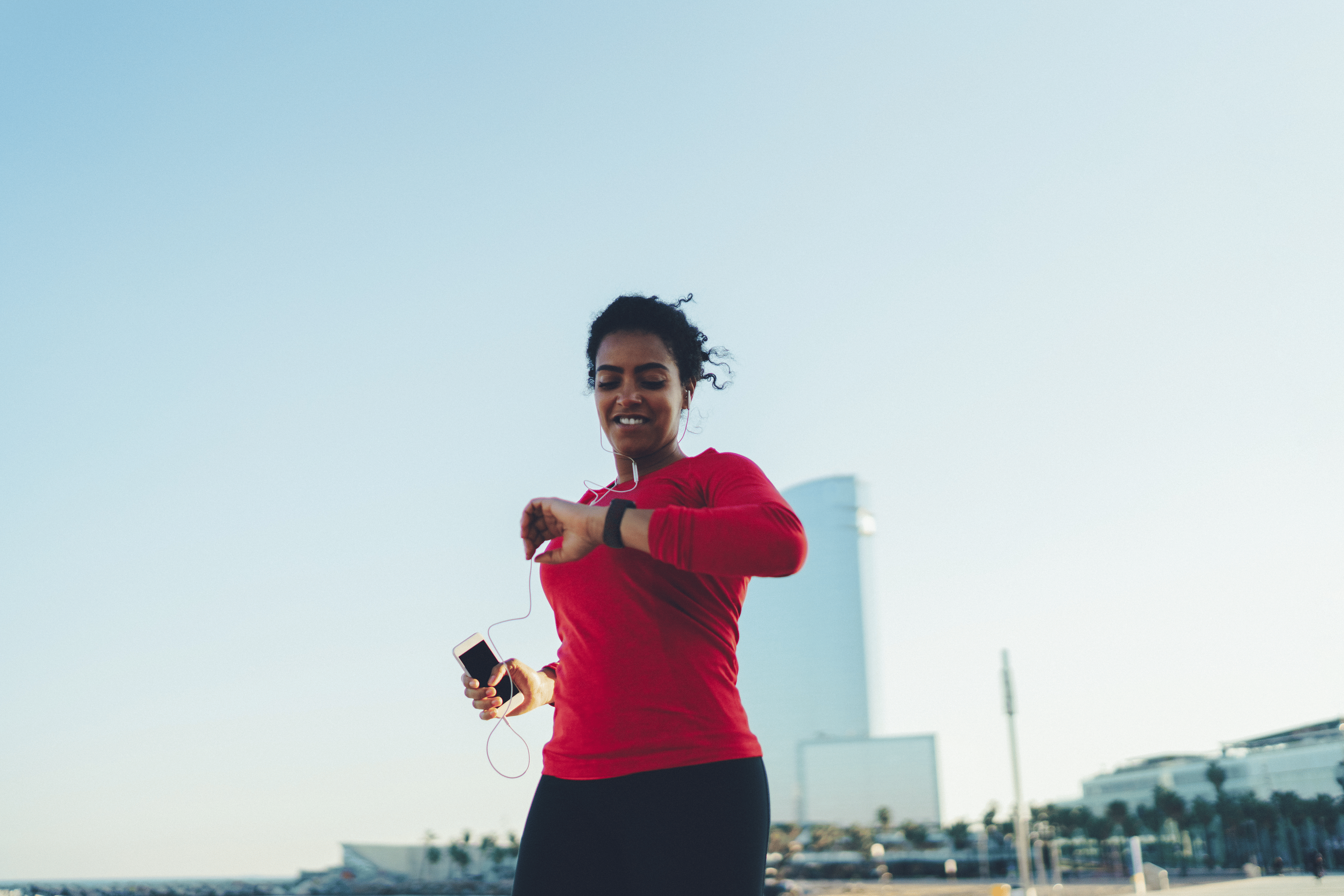 Woman on a run checking her heart rate on her fitness tracker