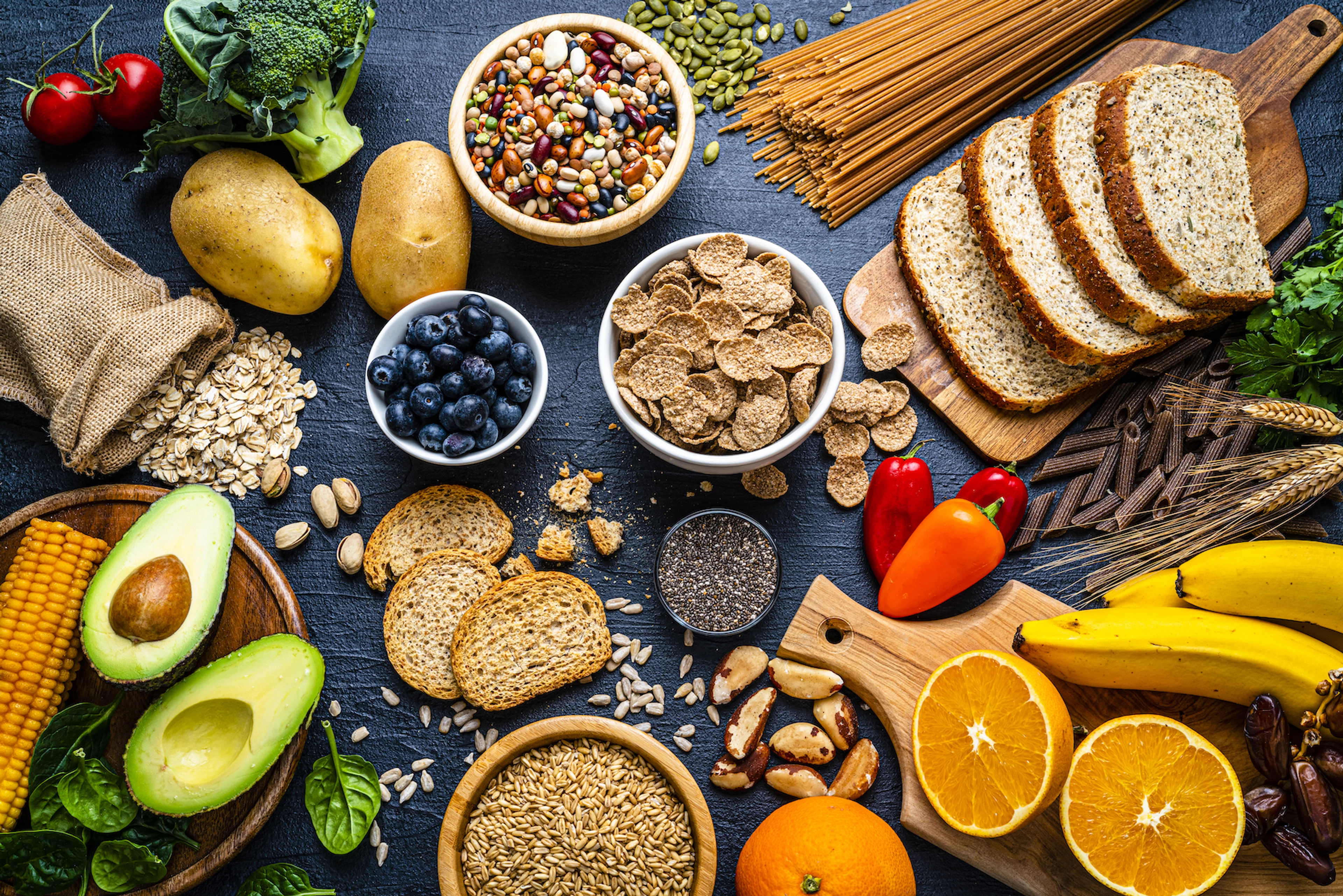 A spread of macronutrient sources like fruits, legumes, and bread.