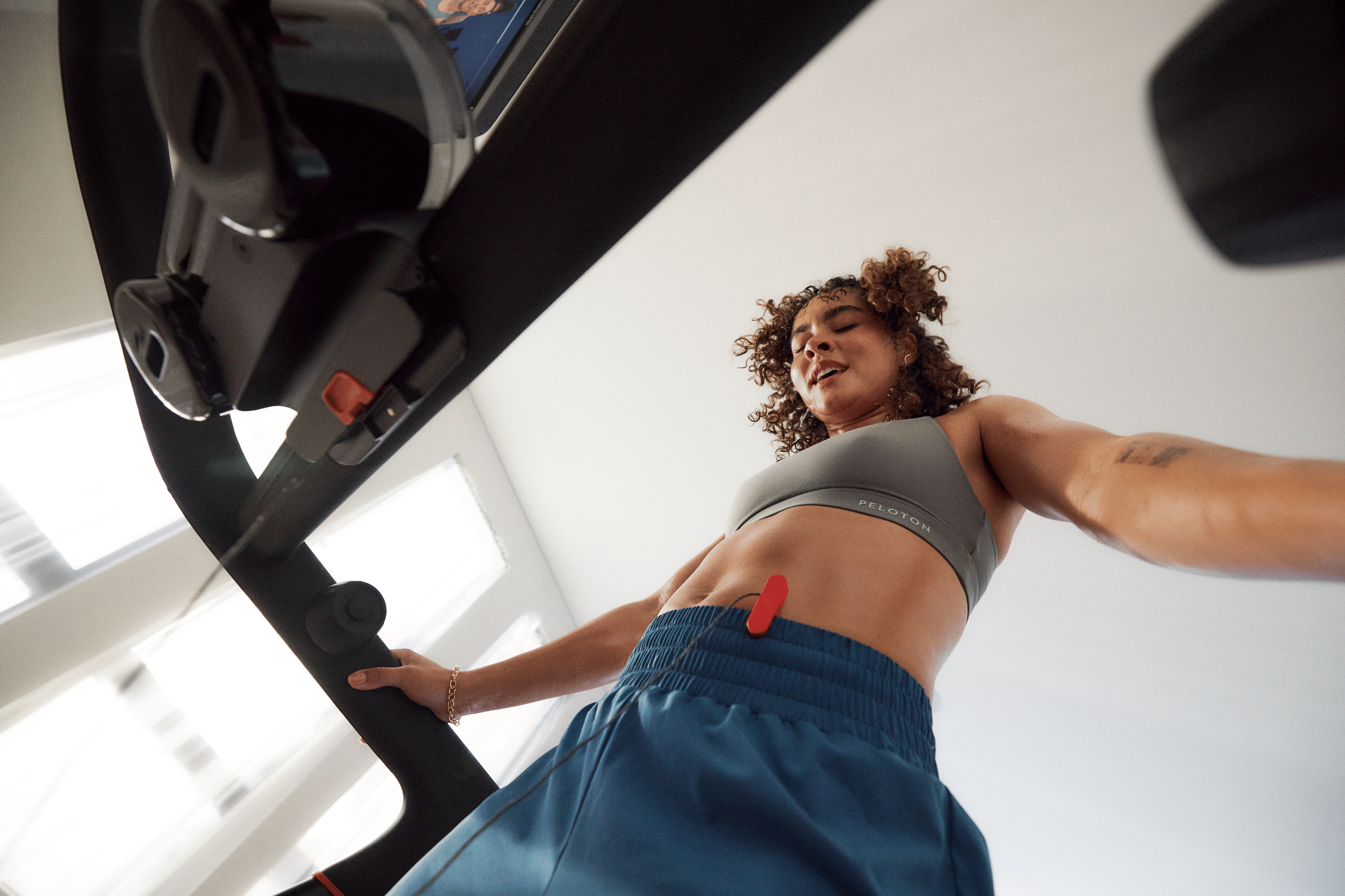 Woman resting during a HILIT high-intensity low-impact training workout on the Peloton Tread.