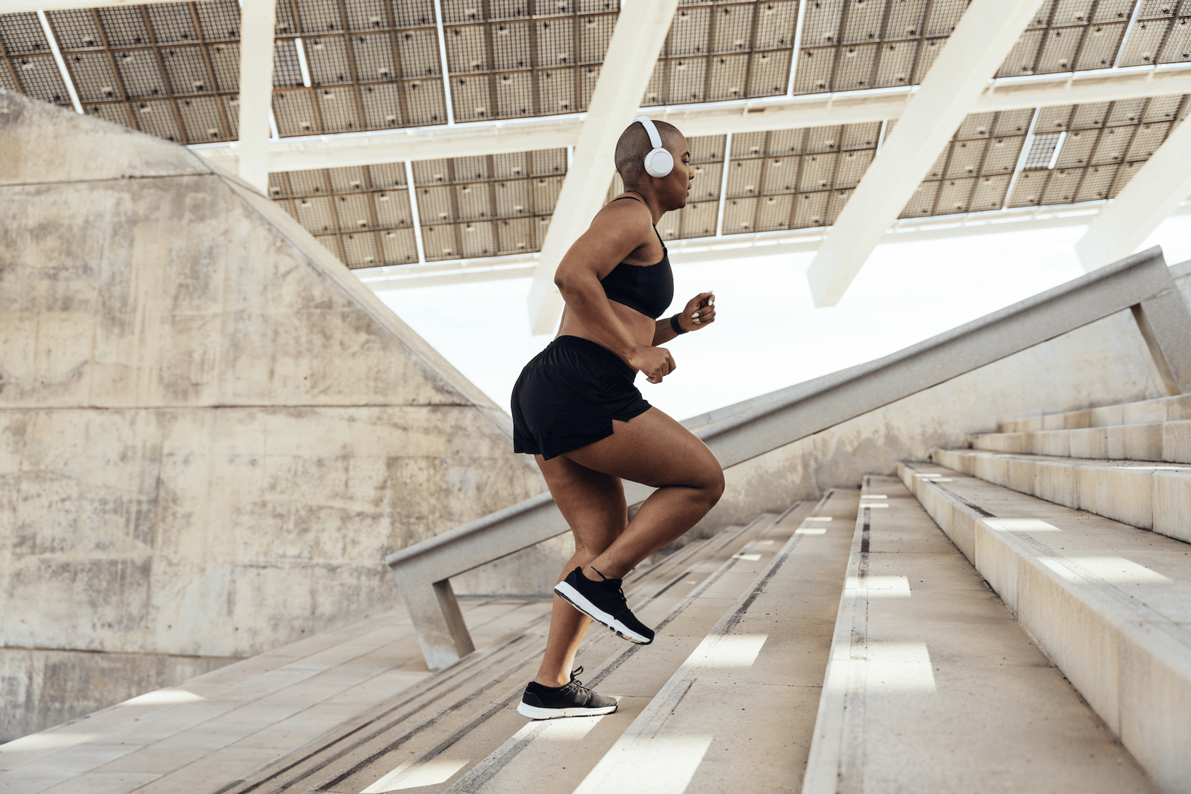 A woman running up a set of outdoor stairs in warm weather.