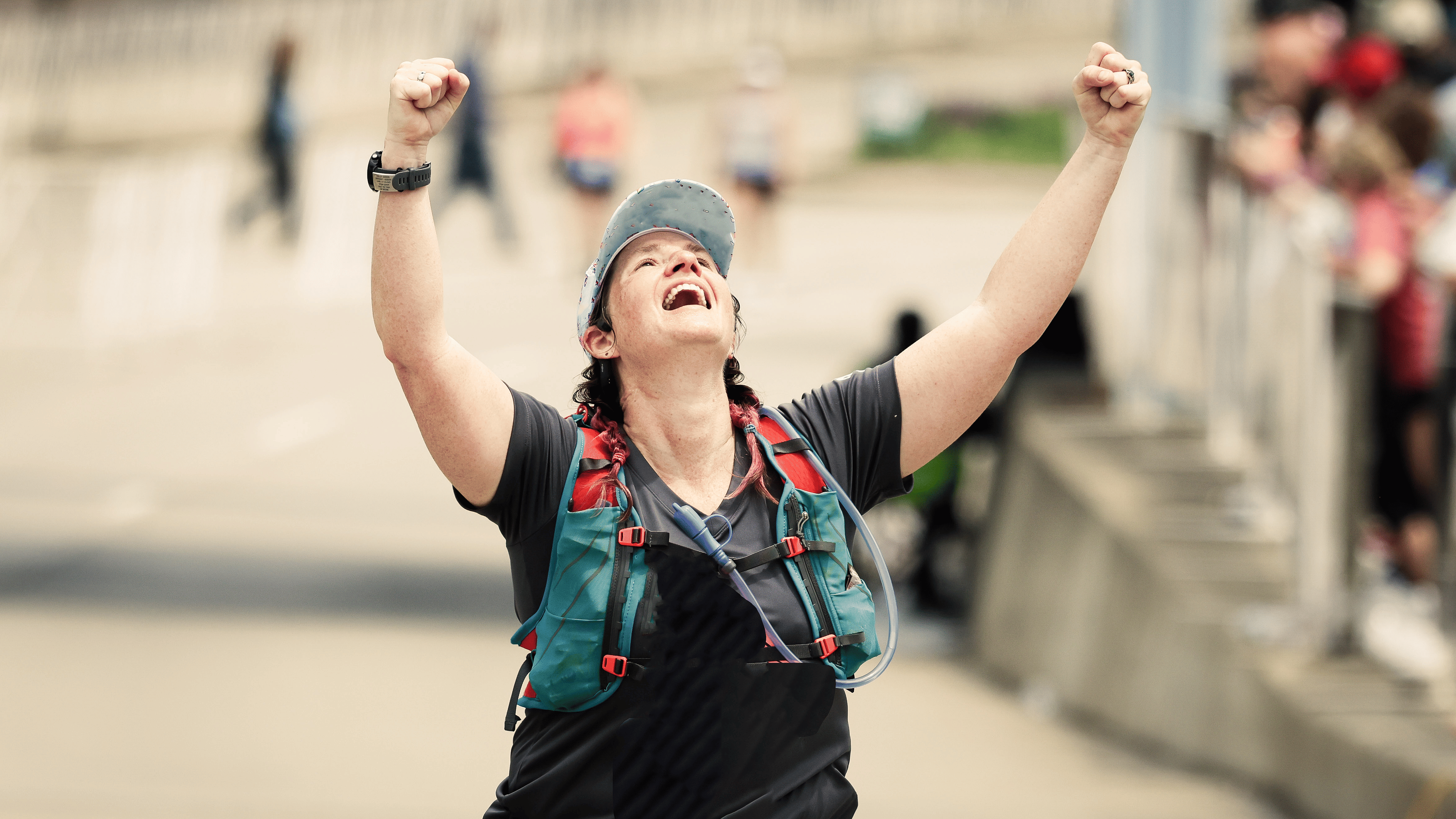 Woman celebrating after crossing the finish line while walking a marathon.
