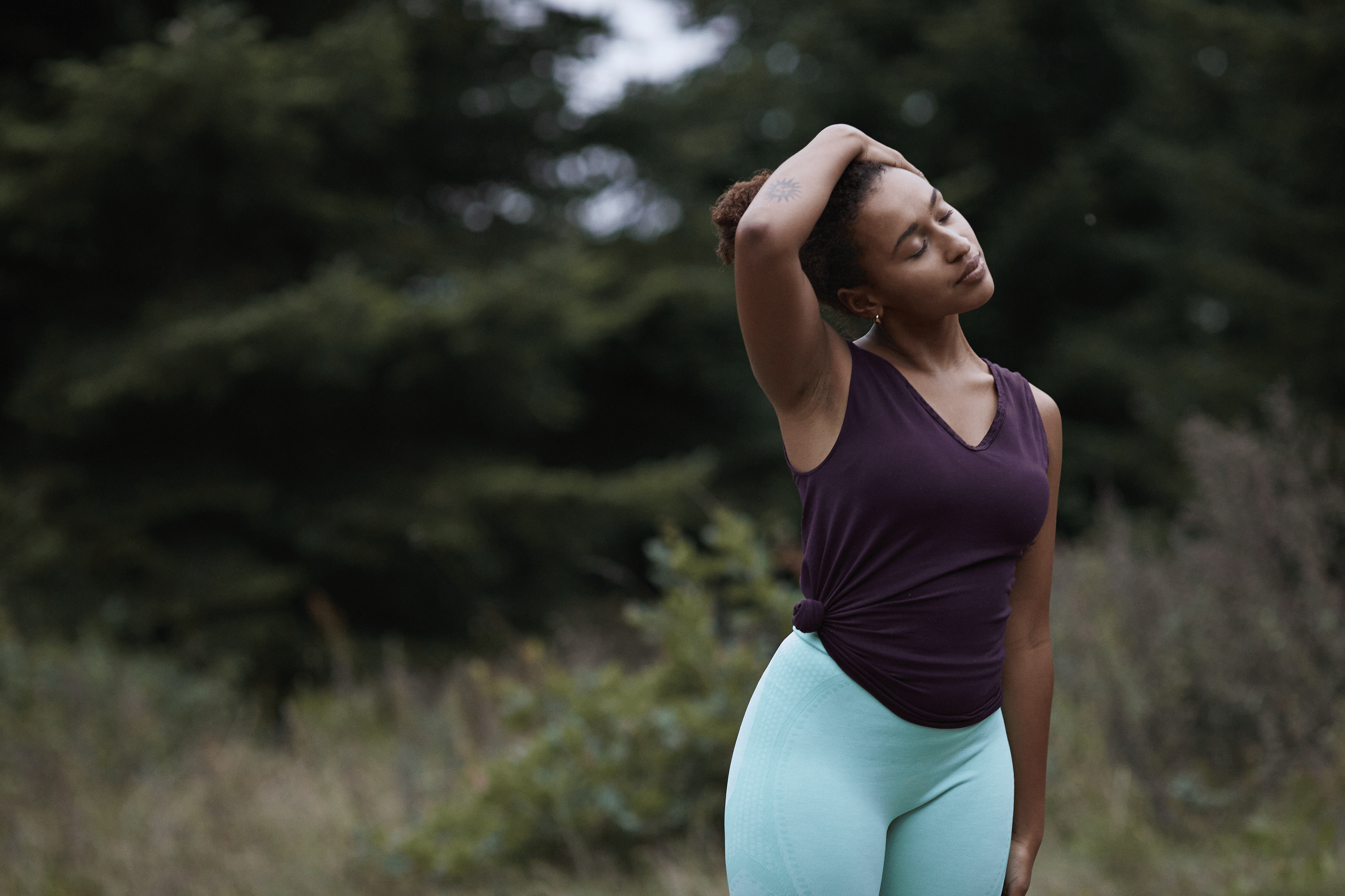Woman stretches neck outdoors 