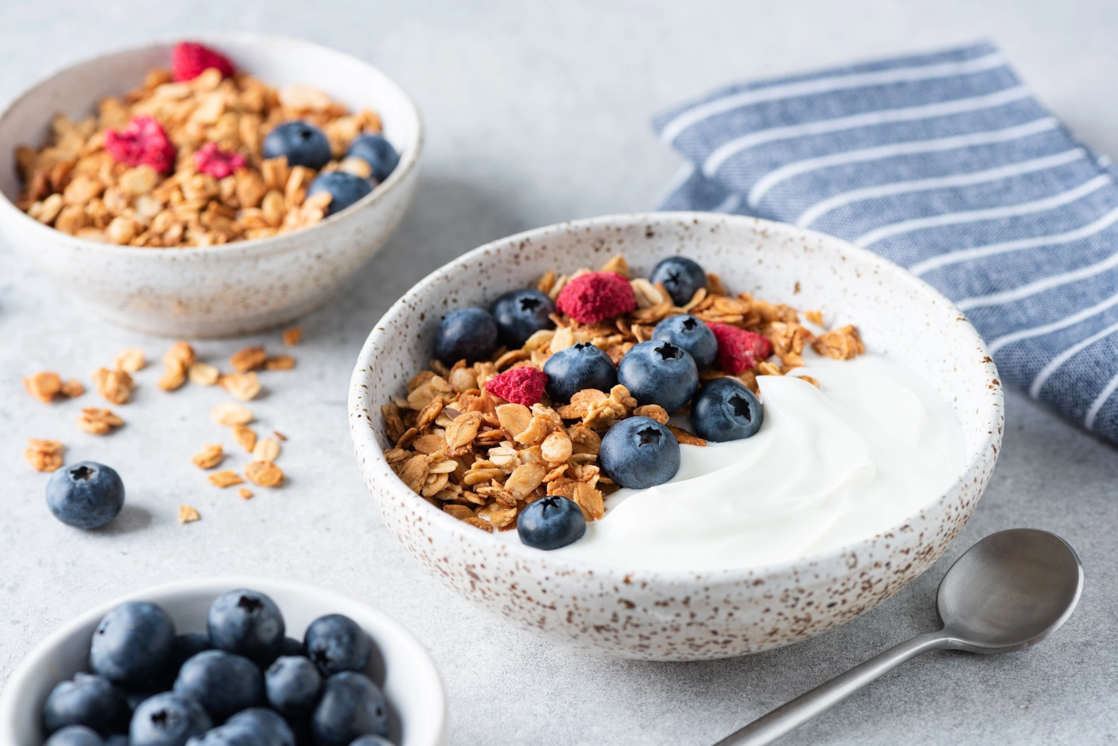 A bowl of Greek yogurt, a non-meat protein source, with granola and blueberries.