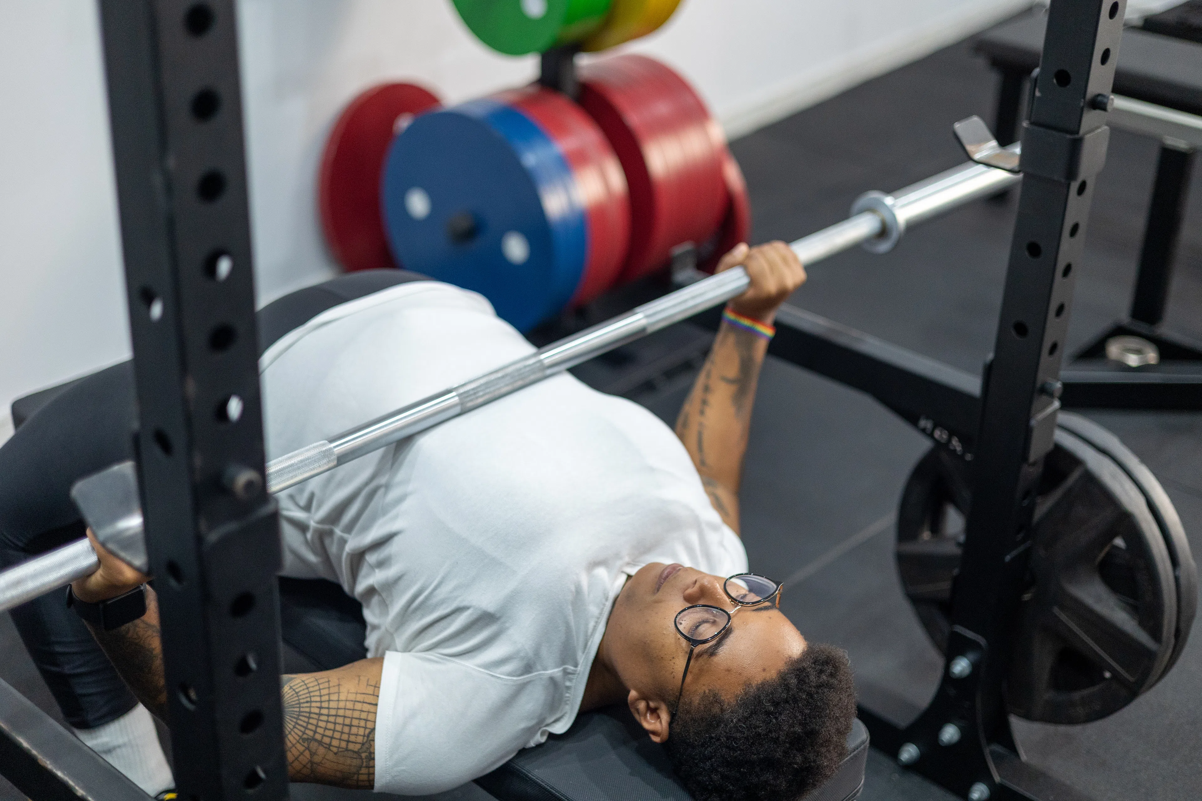 Person in the gym doing a heavy barbell bench press.