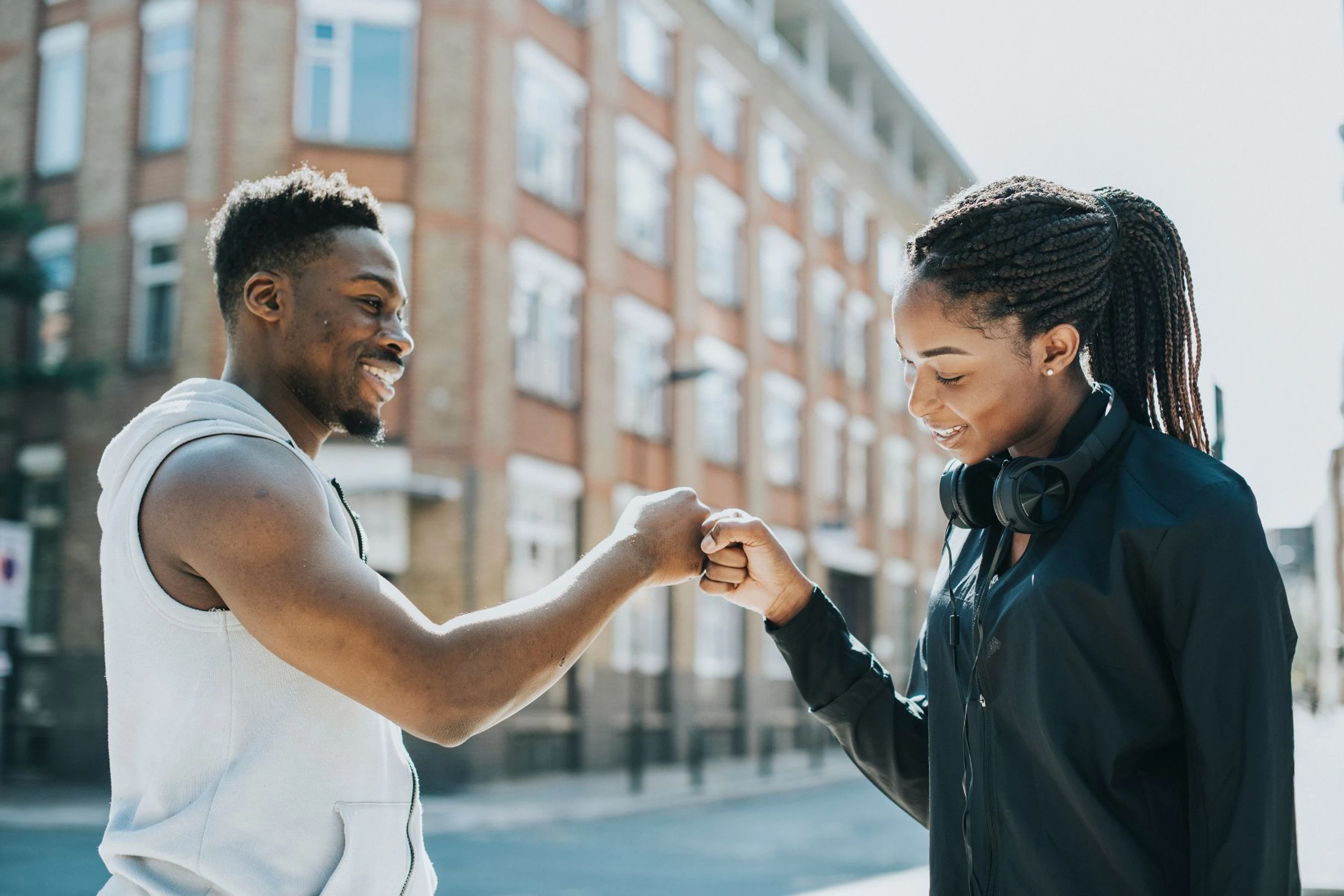 Man and woman fistbumping outside
