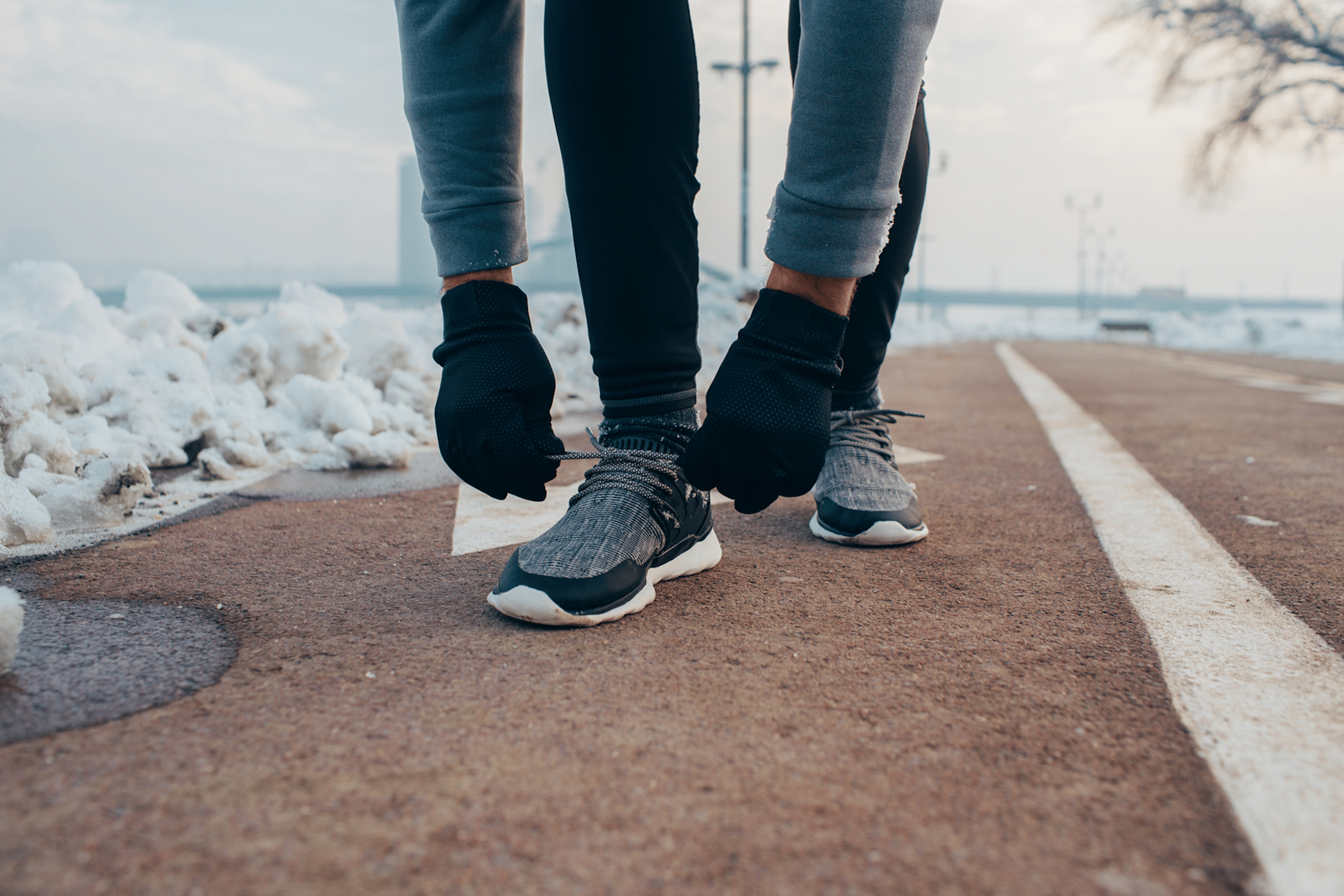 Woman ties sneakers during a cold-weather run