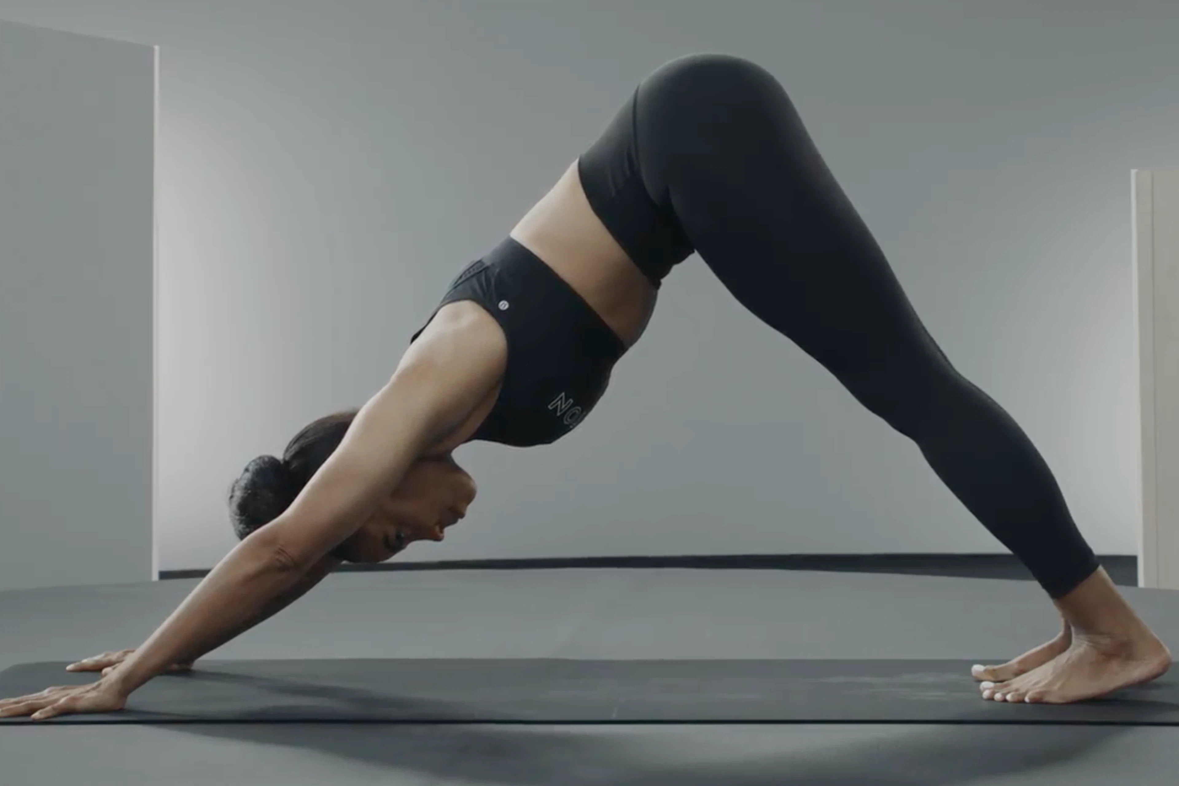 Woman practices Downward-Facing Dog, a yoga pose for better posture