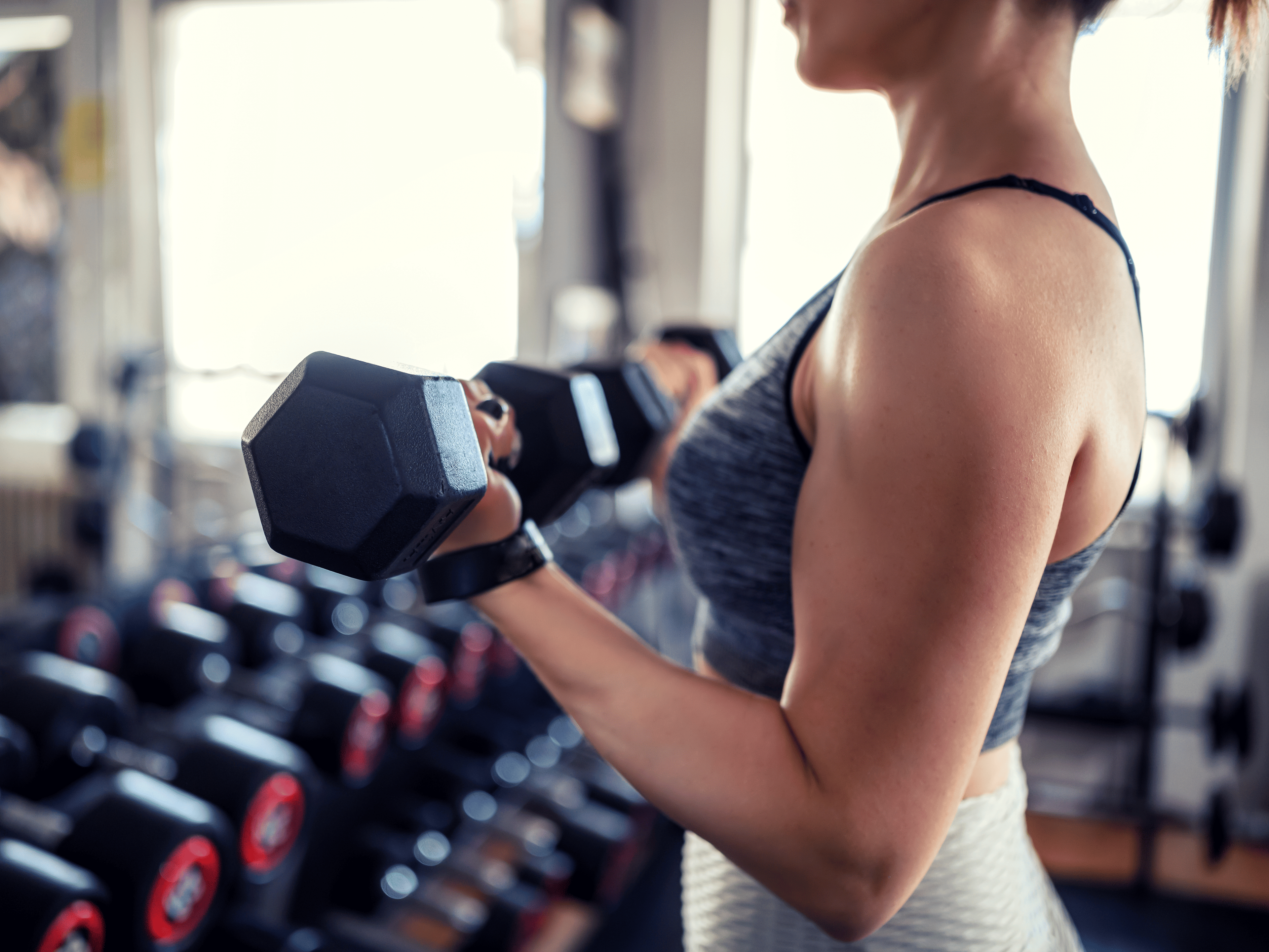 Woman lifting weights at gym 